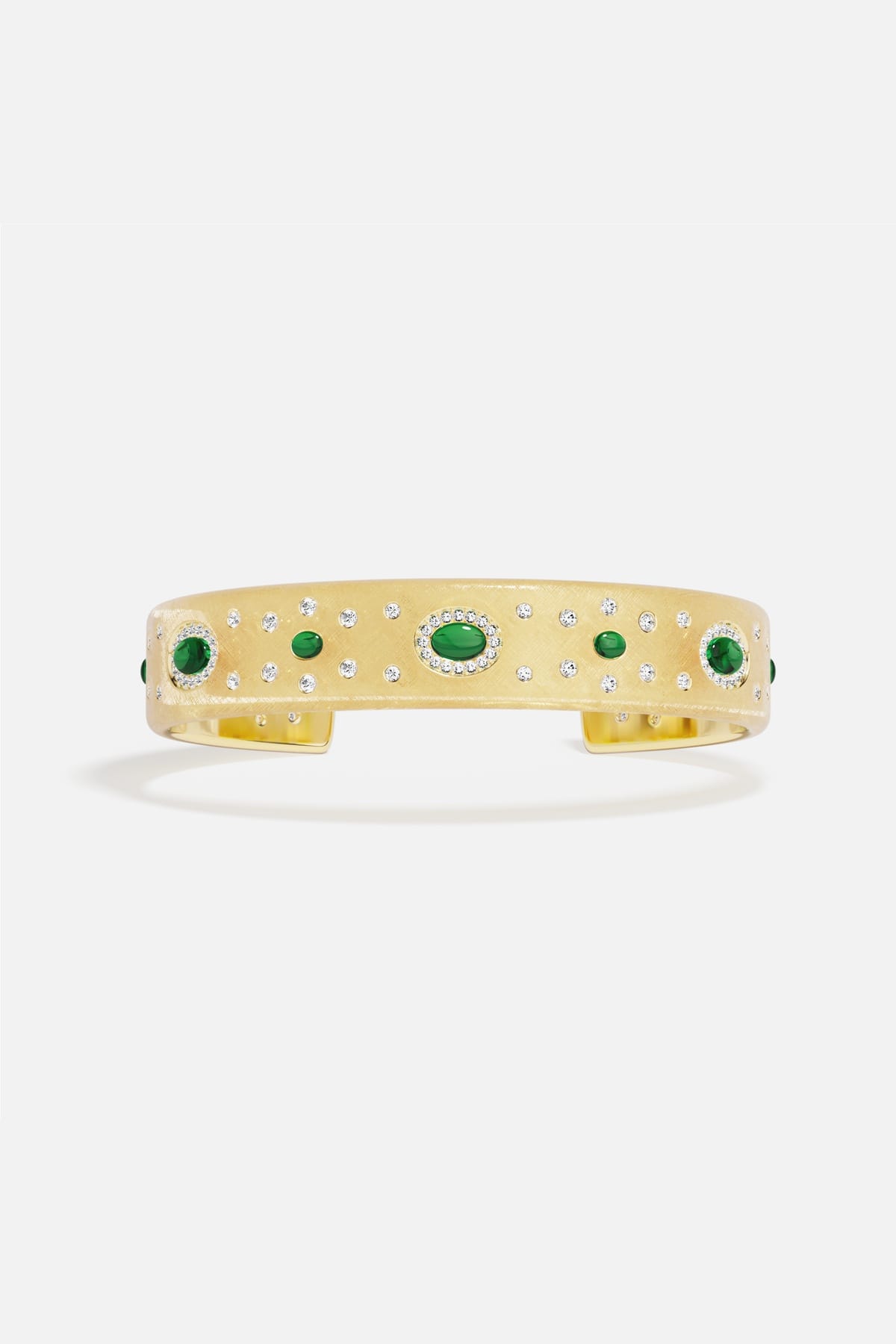 APM Monaco cuff bracelet, golden radiance sprinkled with green accents, quietly regal.