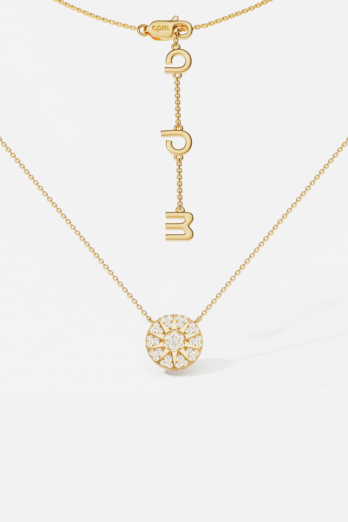 APM Monaco necklace in gold color, a radiant pavé medallion glowing with quiet charm.