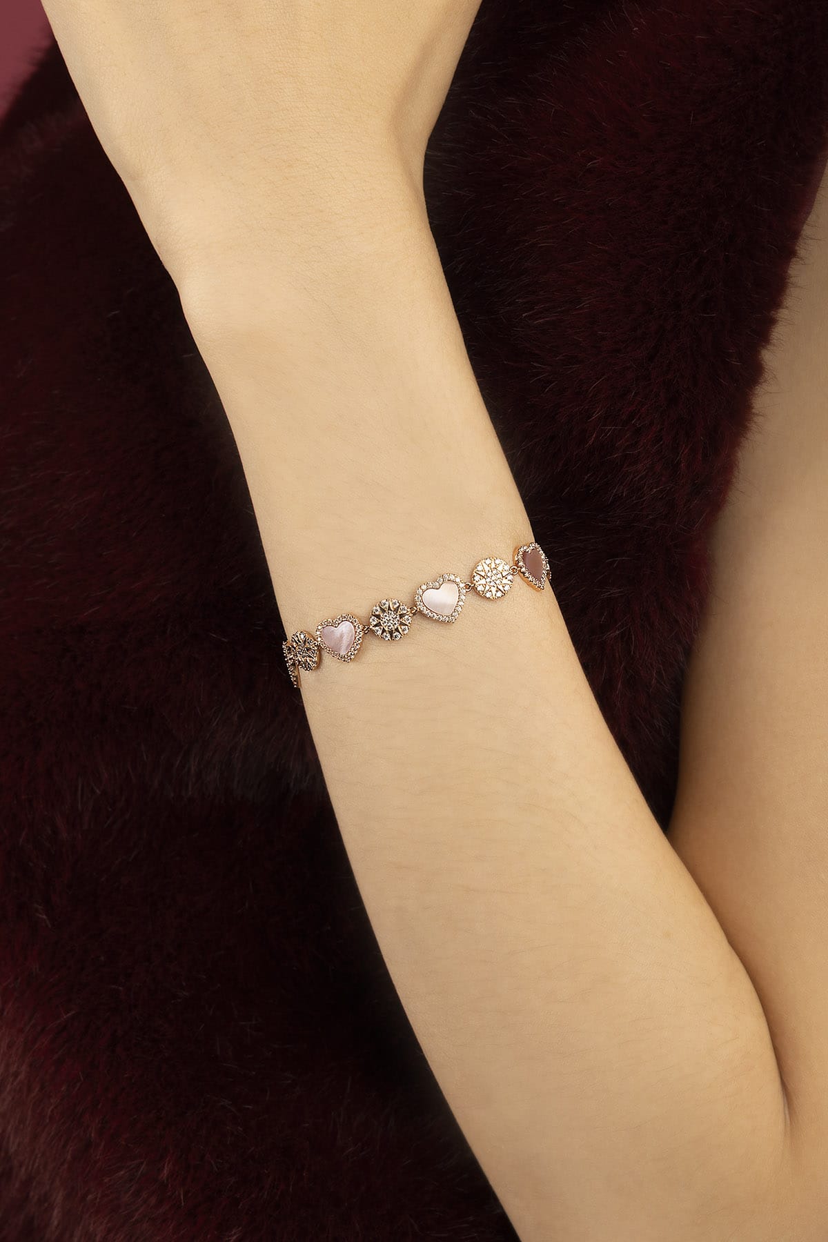 Woman wearing APM Monaco bracelet, a delicate romance in soft rosy hues.