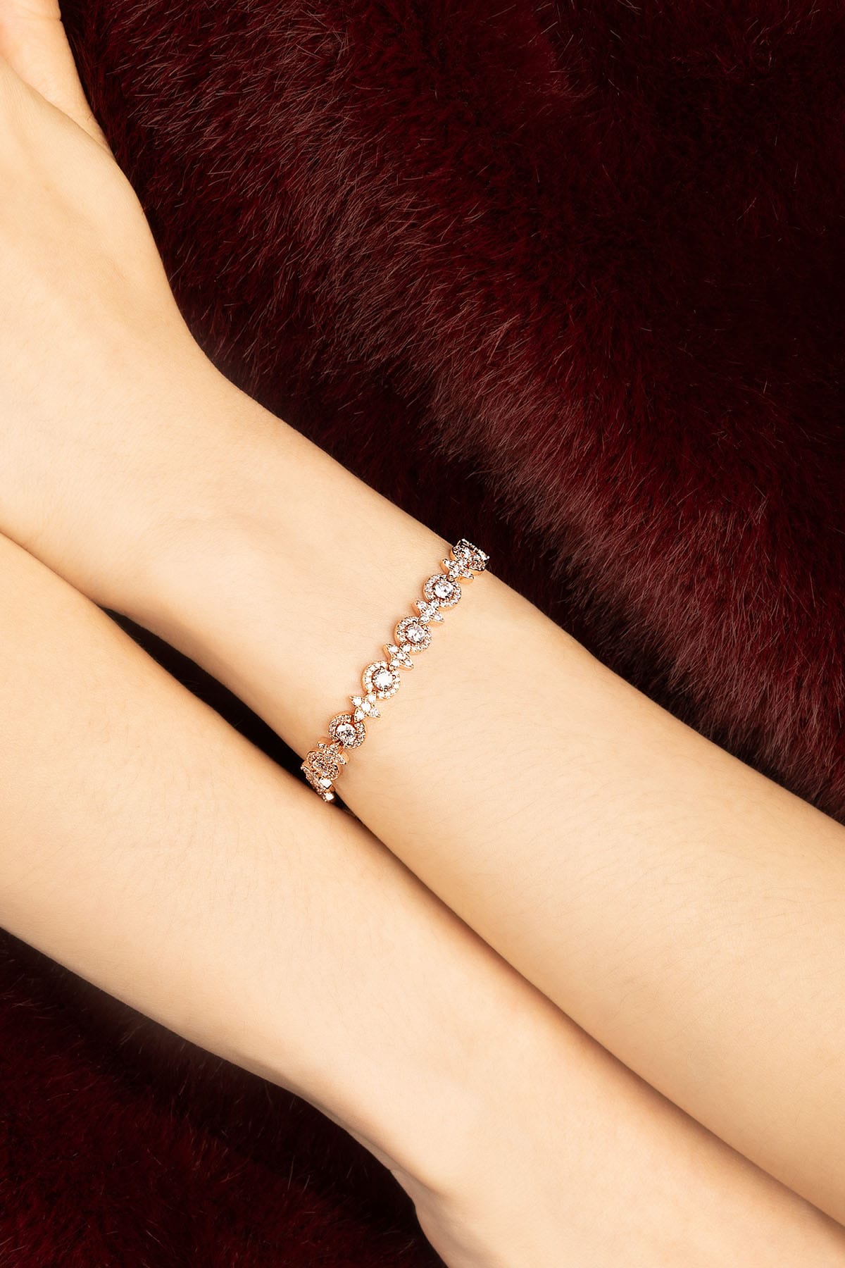 Woman wearing APM bracelet, a delicate sparkle against velvet warmth.