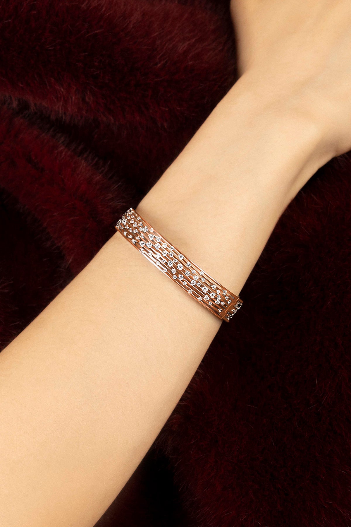 Woman wearing APM Monaco bracelet, a shimmering rose whisper against velvet.