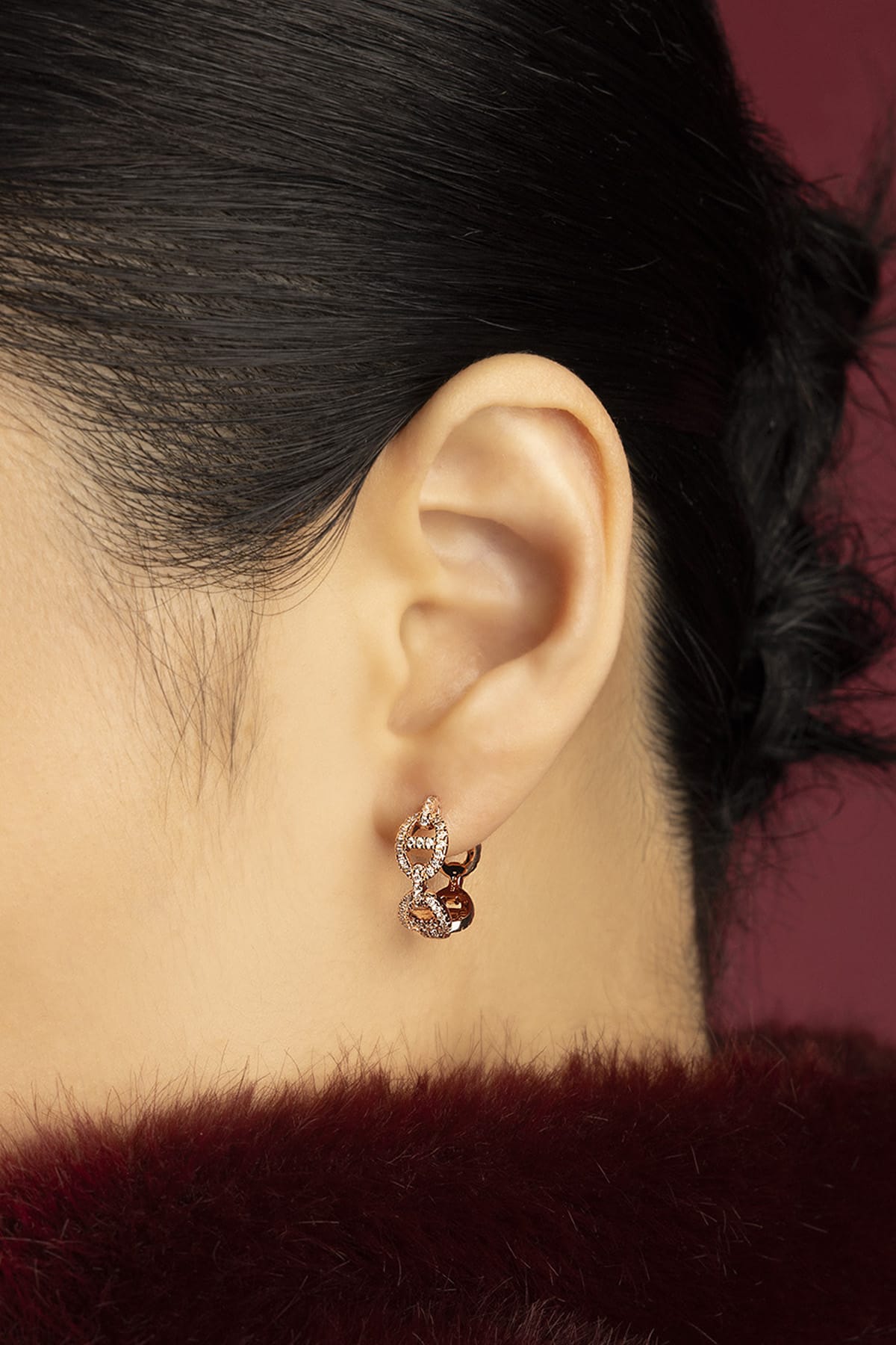 Woman wearing APM Morse Earrings, a chained whisper of rose-toned elegance.