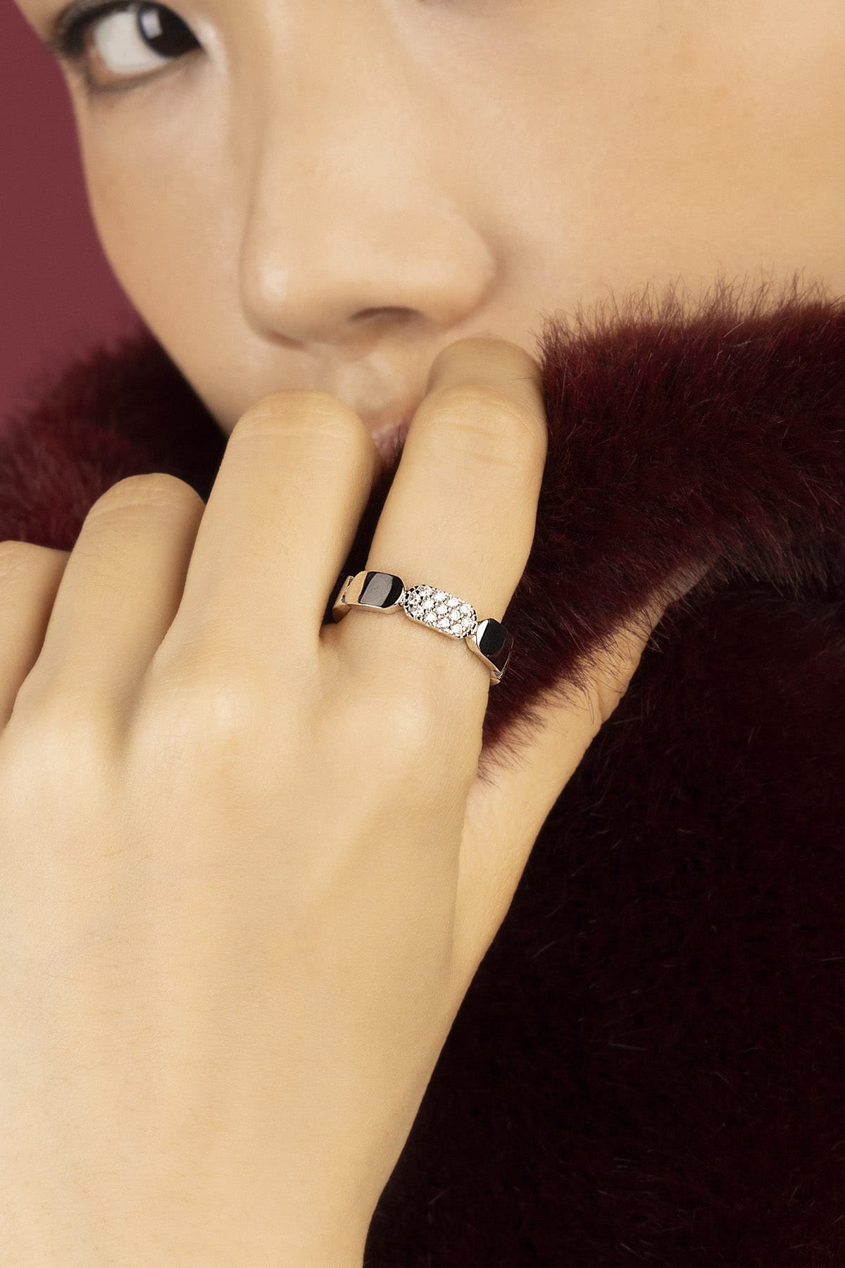 Woman wearing APM Morse Ring, a whisper of modern elegance against soft fur.