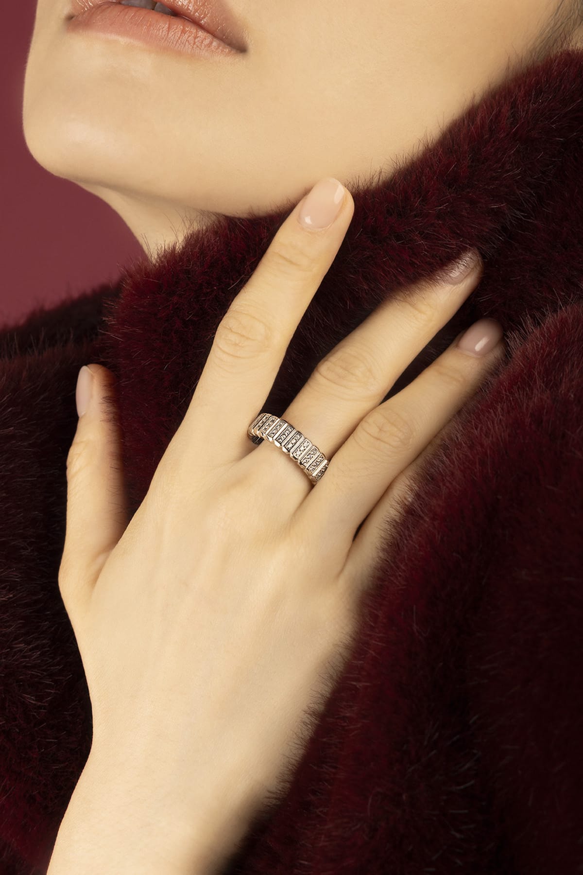 Woman wearing APM Morse Ring, a quiet sparkle against soft burgundy warmth.