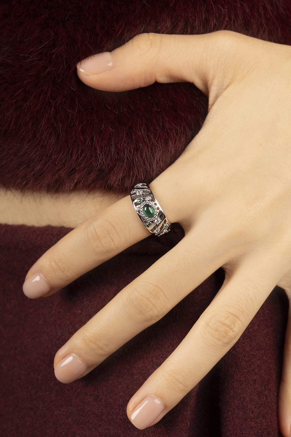 Woman wearing APM Ring, a green whisper of vintage elegance in rhodium finish.