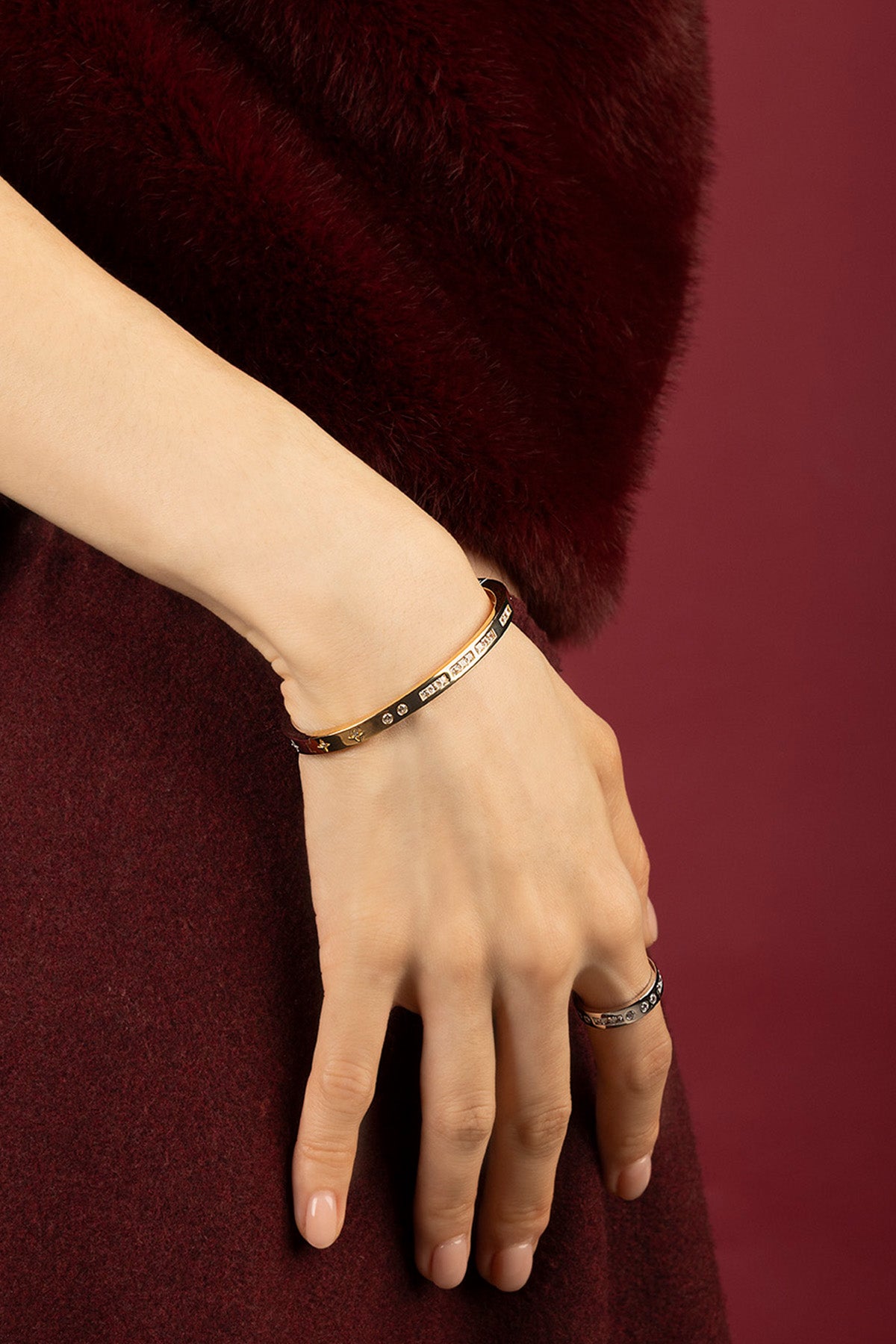 Woman wearing APM Monaco bangle, a golden whisper of winter elegance.