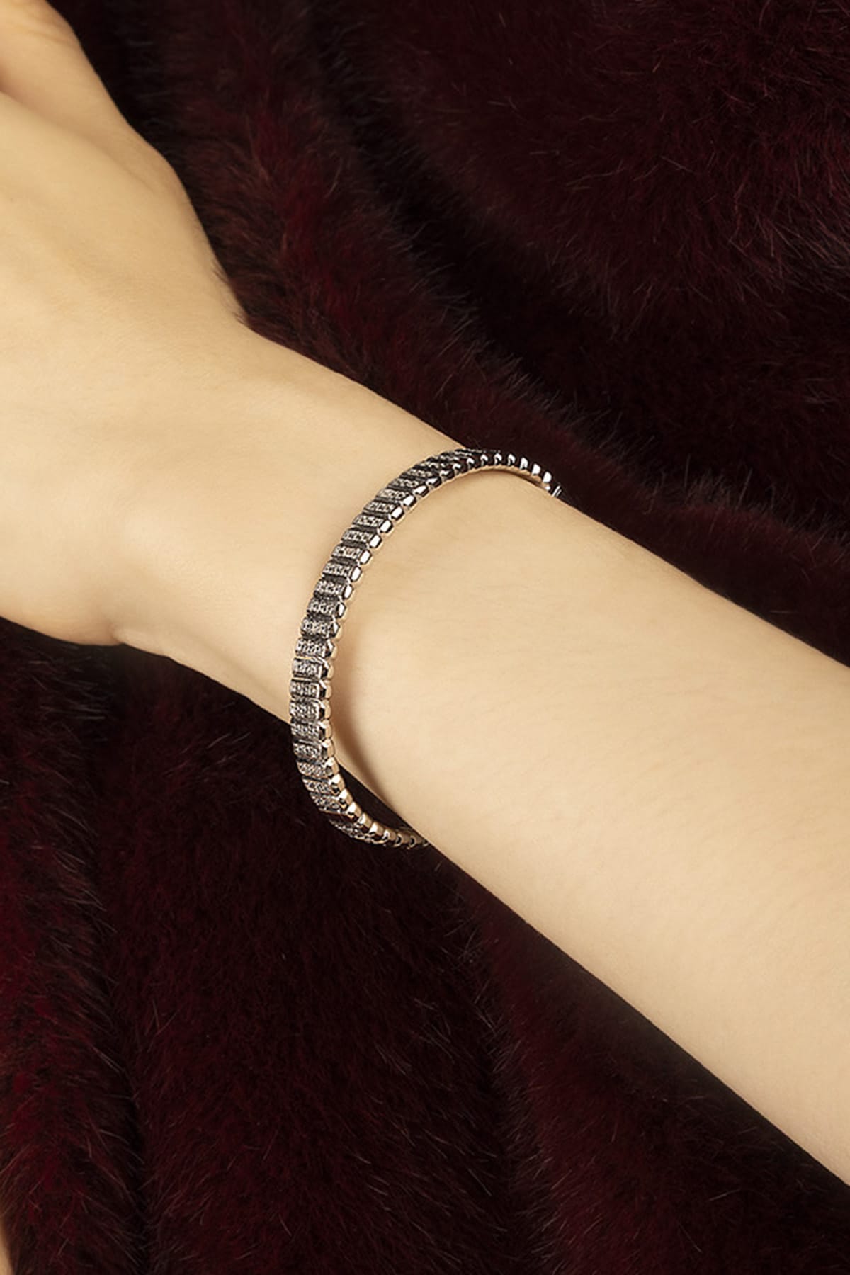 Woman wearing APM Monaco bracelet in rhodium finish, a whisper of quiet glamour.