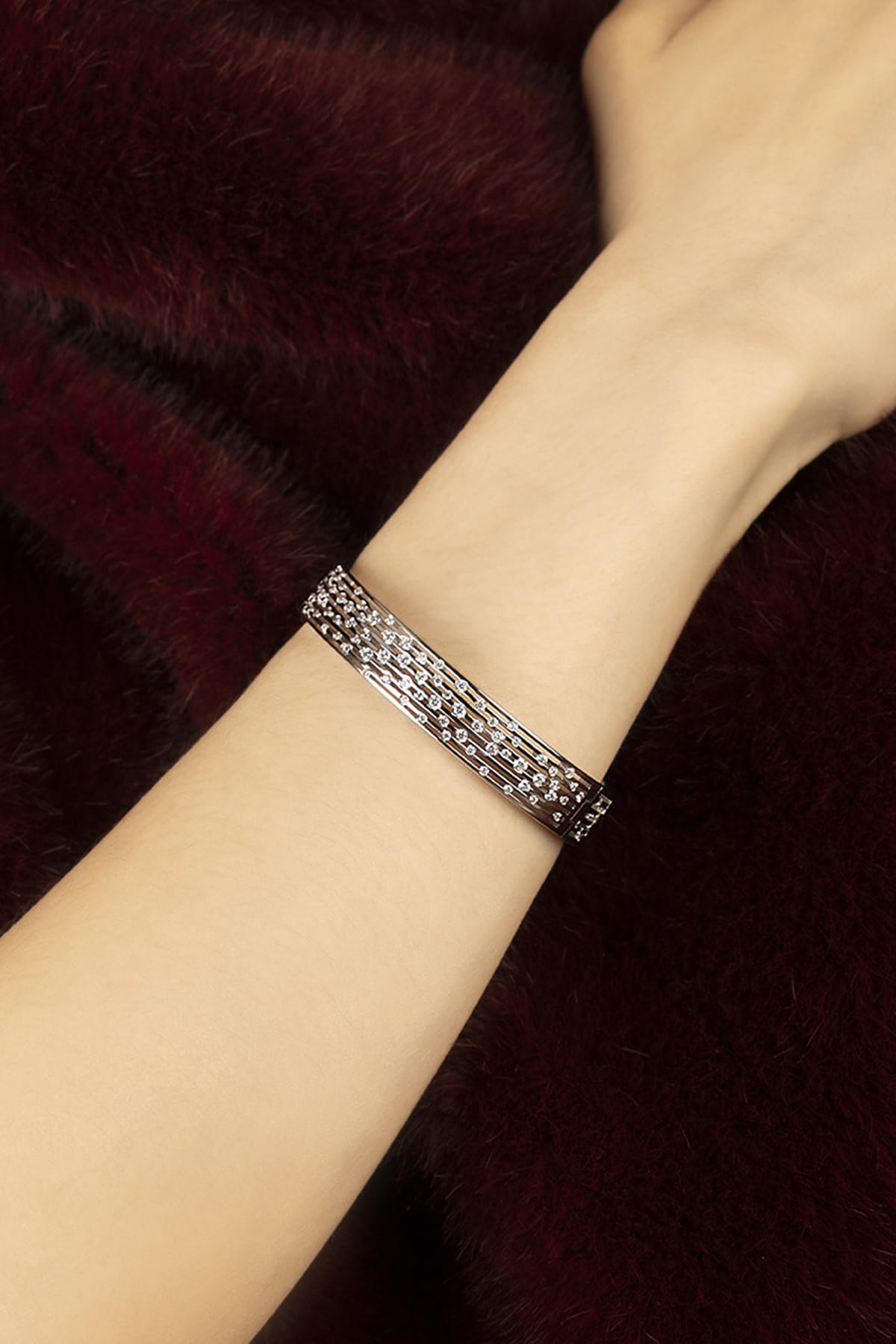 Woman wearing APM Bracelet in rhodium finish, a shimmering whisper of modern elegance.