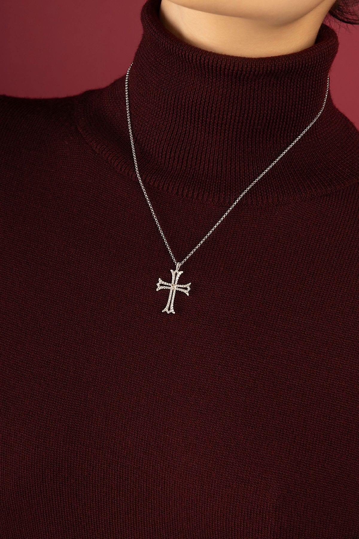 Woman wearing APM cross pendant necklace, a quiet emblem of timeless grace.
