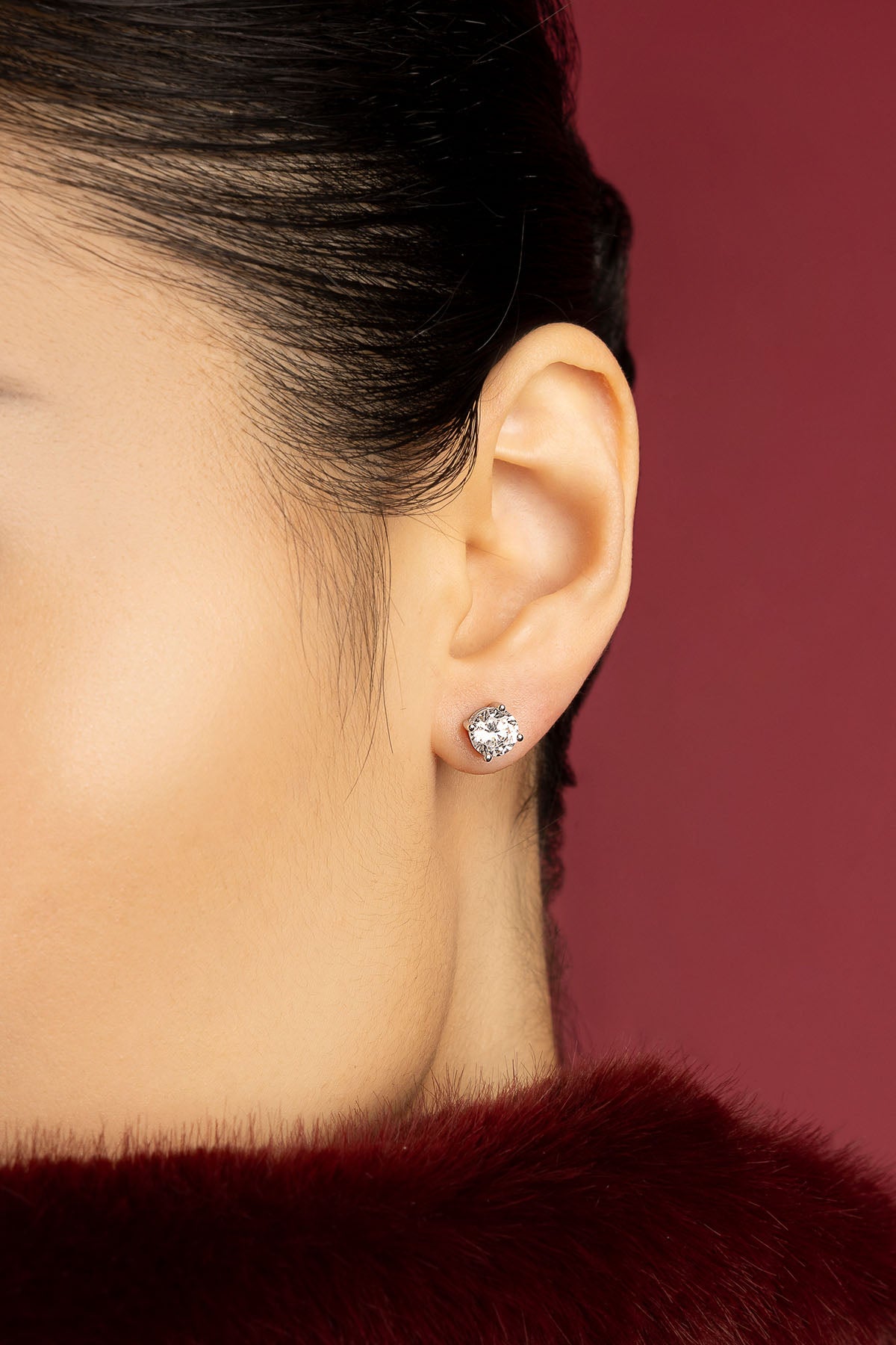 Woman wearing APM Monaco stud earrings, a crystalline spark of quiet elegance.