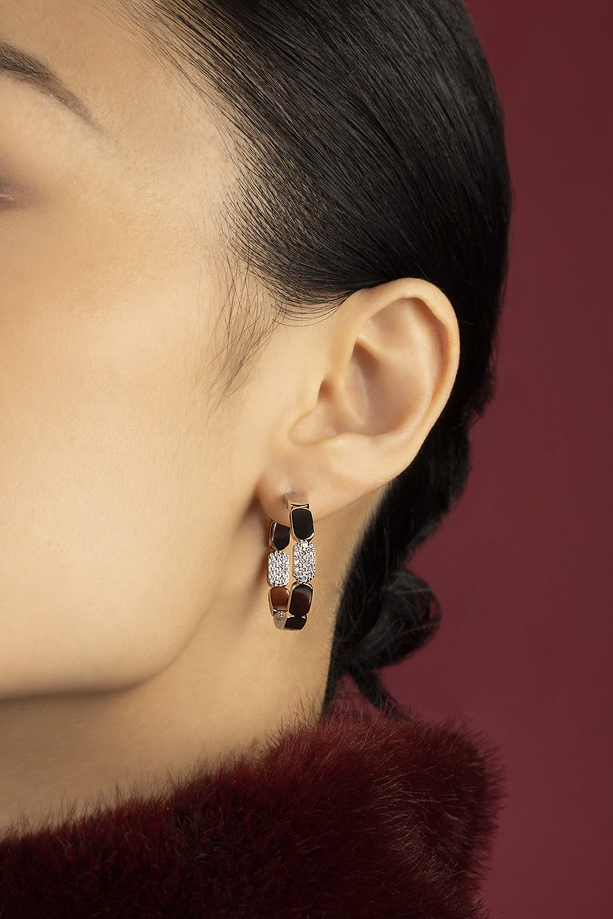 Woman wearing APM Monaco hoop earrings, a bold whisper of modern elegance.