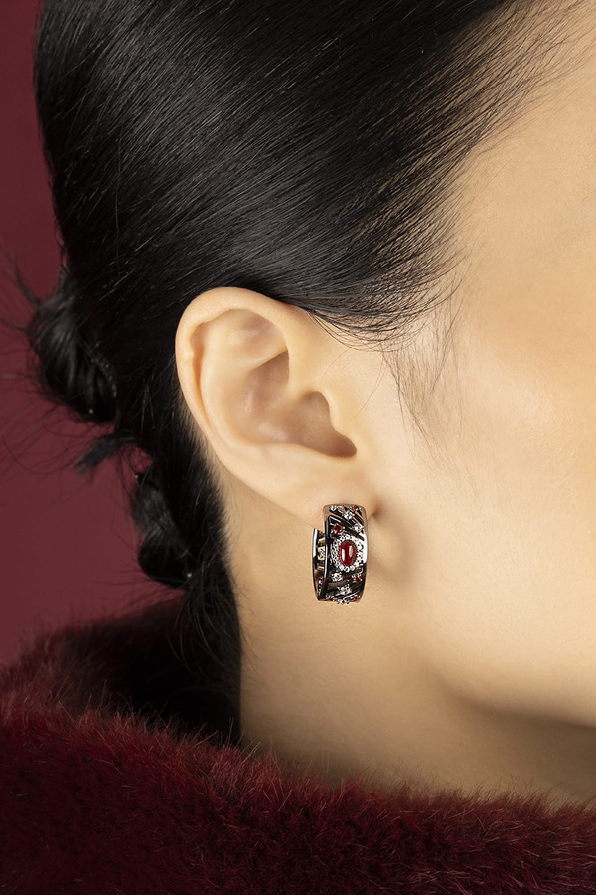 Woman wearing APM Hoop Earrings, a bold whisper of red and rhodium finish.