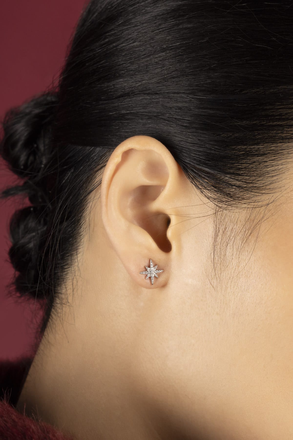 Woman wearing APM star stud earrings, a quiet sparkle of celestial charm.