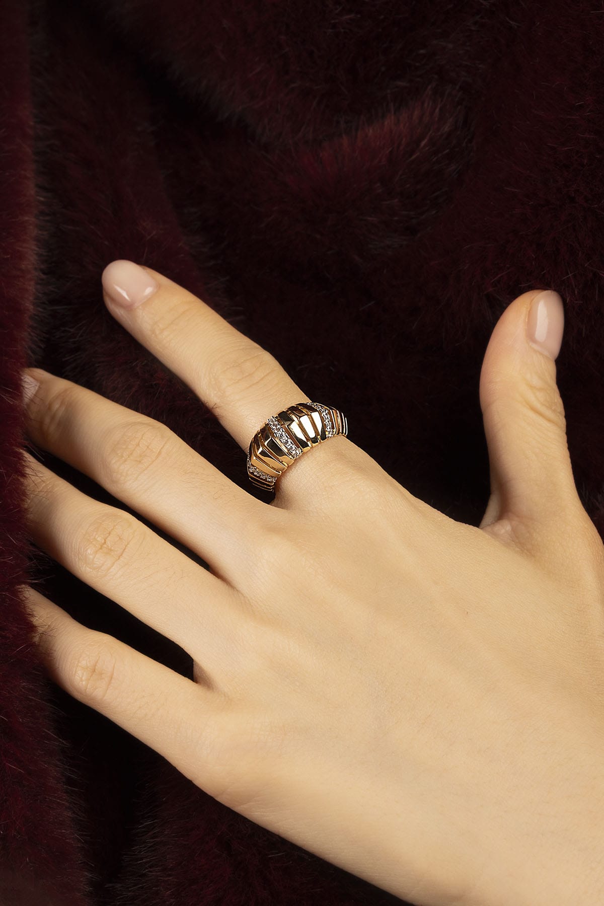 Woman wearing APM ring, a golden statement of quiet winter allure.