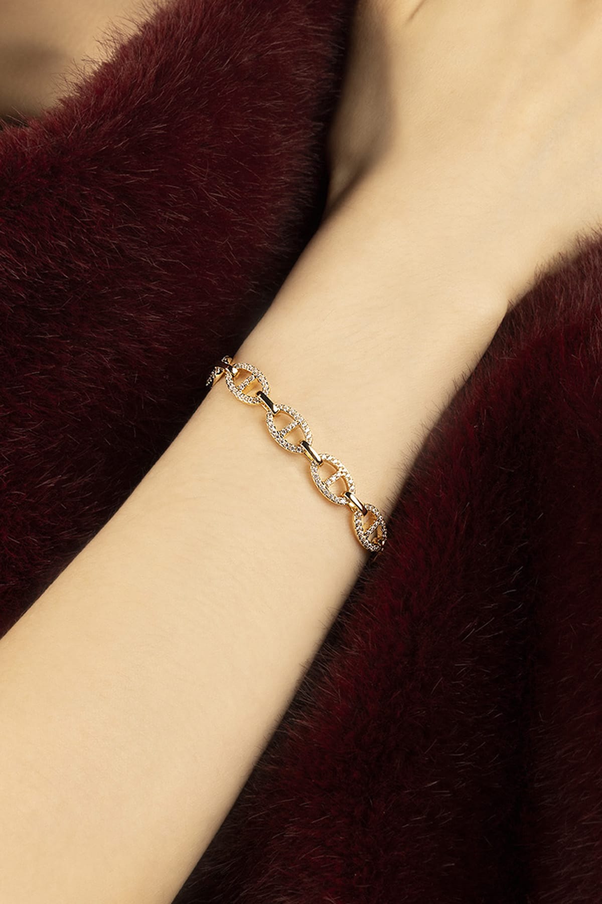 Woman wearing APM Monaco chain bracelet, a golden whisper of quiet confidence.