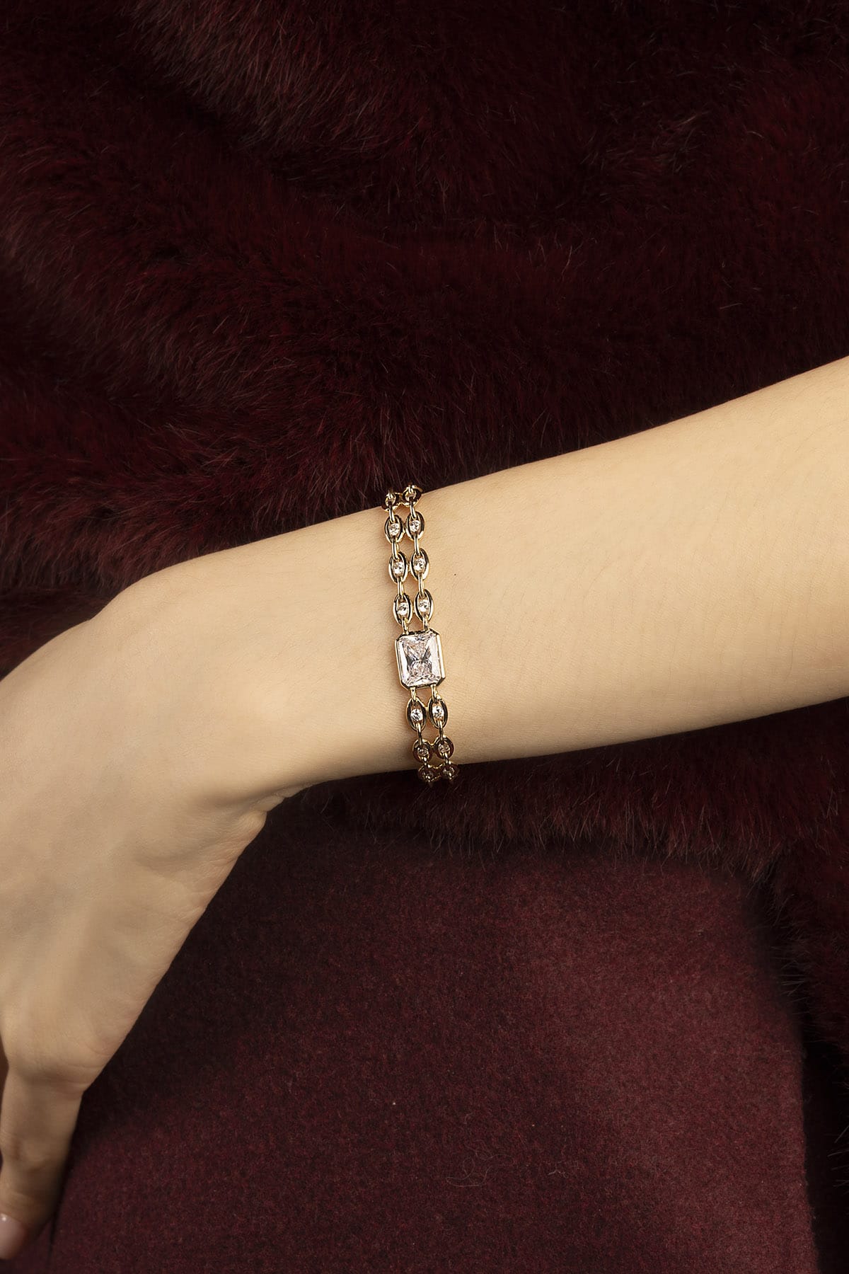 Woman wearing APM Monaco bracelet, a golden whisper of refined elegance.