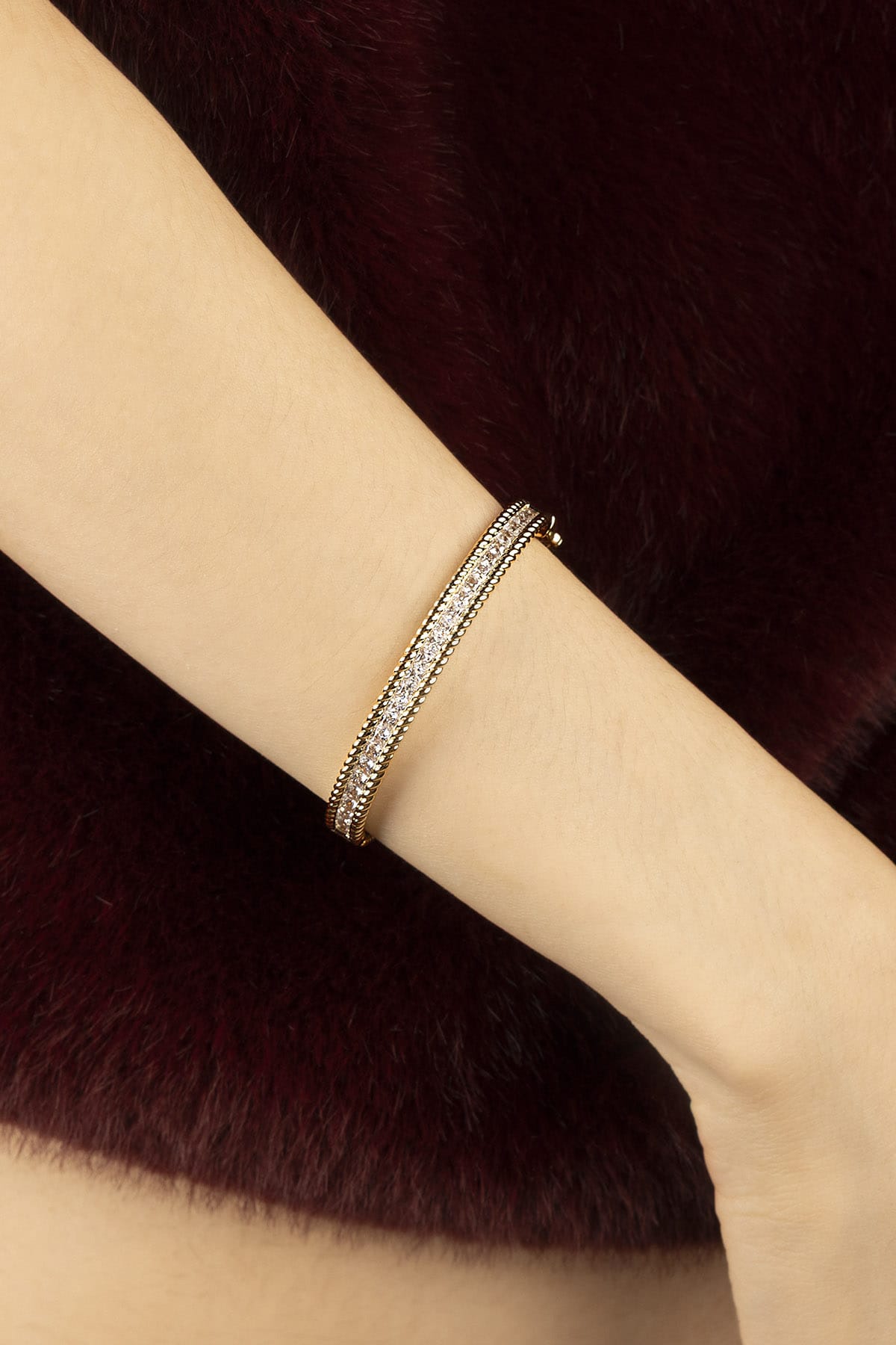 Woman wearing APM bangle, a golden glow of quiet elegance.