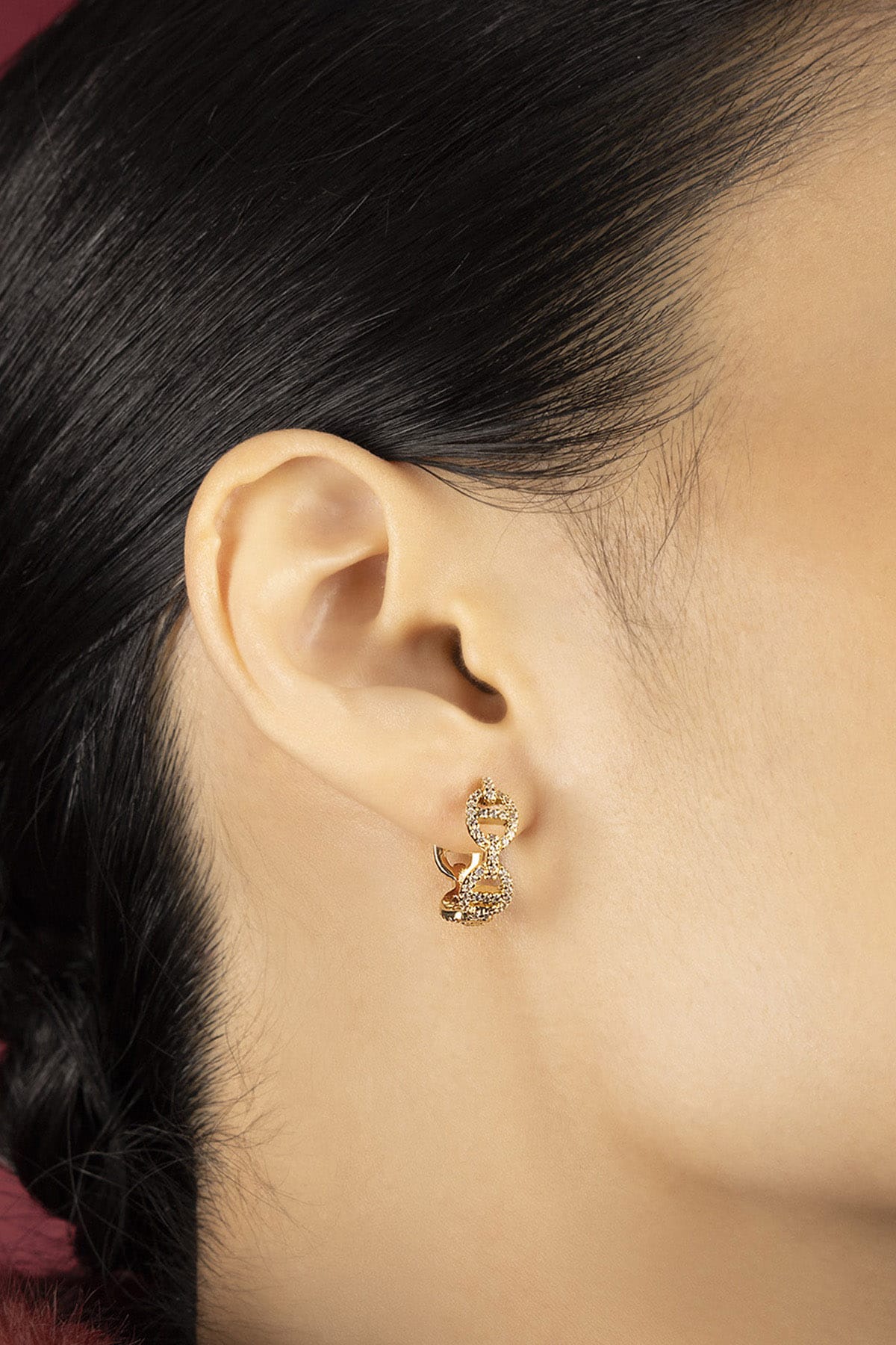 Woman wearing APM Morse Earrings, a golden whisper of contemporary elegance.