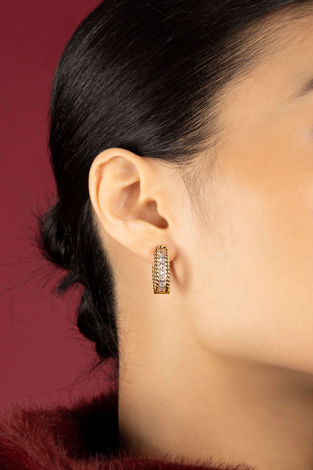 Woman wearing APM hoop earrings, a golden whisper of quiet elegance.