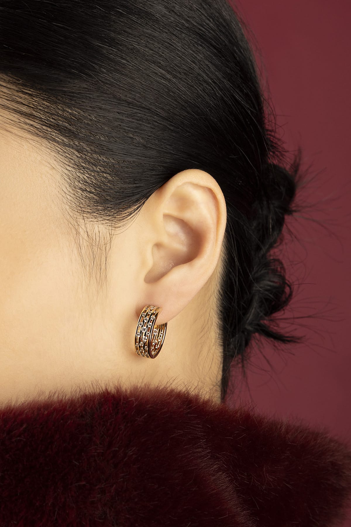 Woman wearing APM Monaco hoop earrings, a golden whisper of quiet allure.