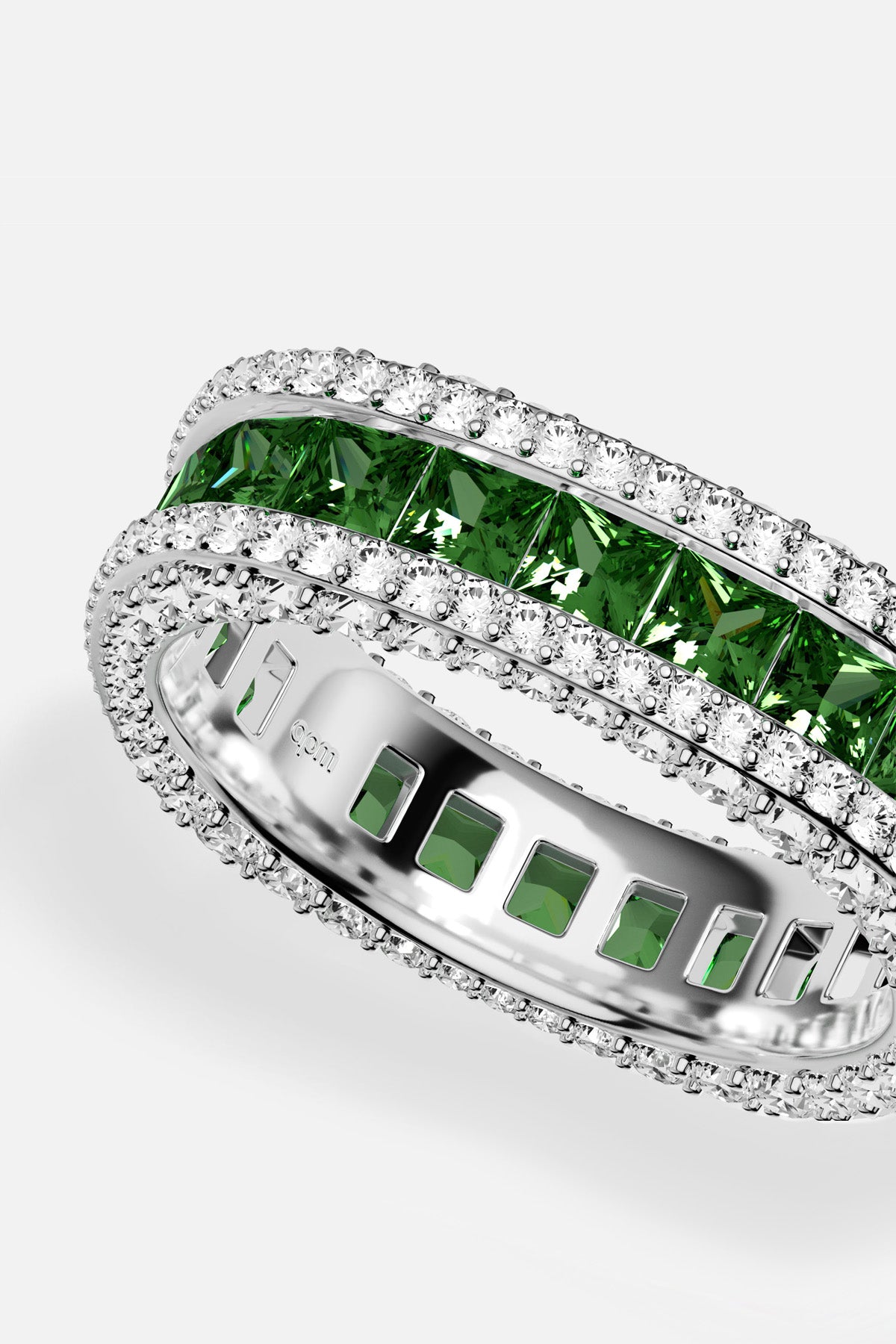 APM Ring, a luminous rhodium finish embracing vivid green stones with quiet brilliance.