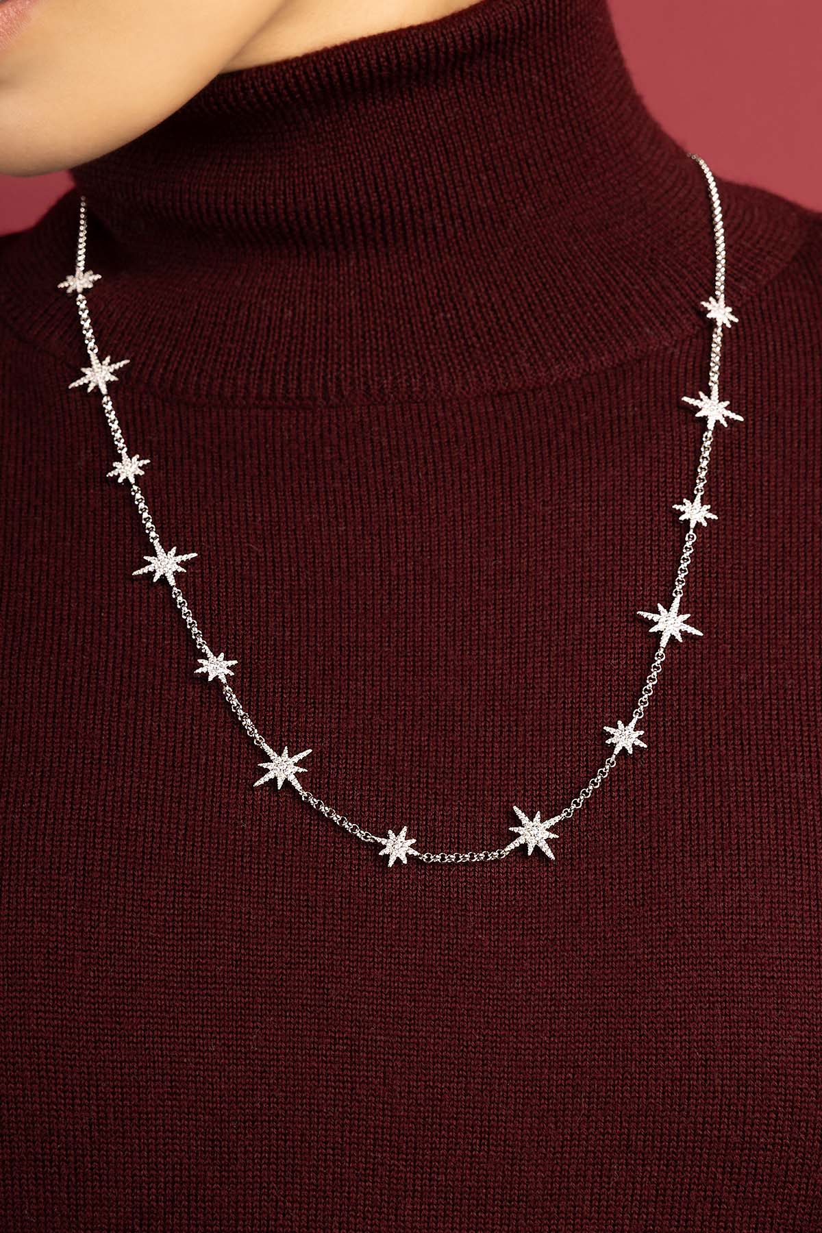Woman wearing APM Météorites Necklace, a constellation of stars grazing the neckline.