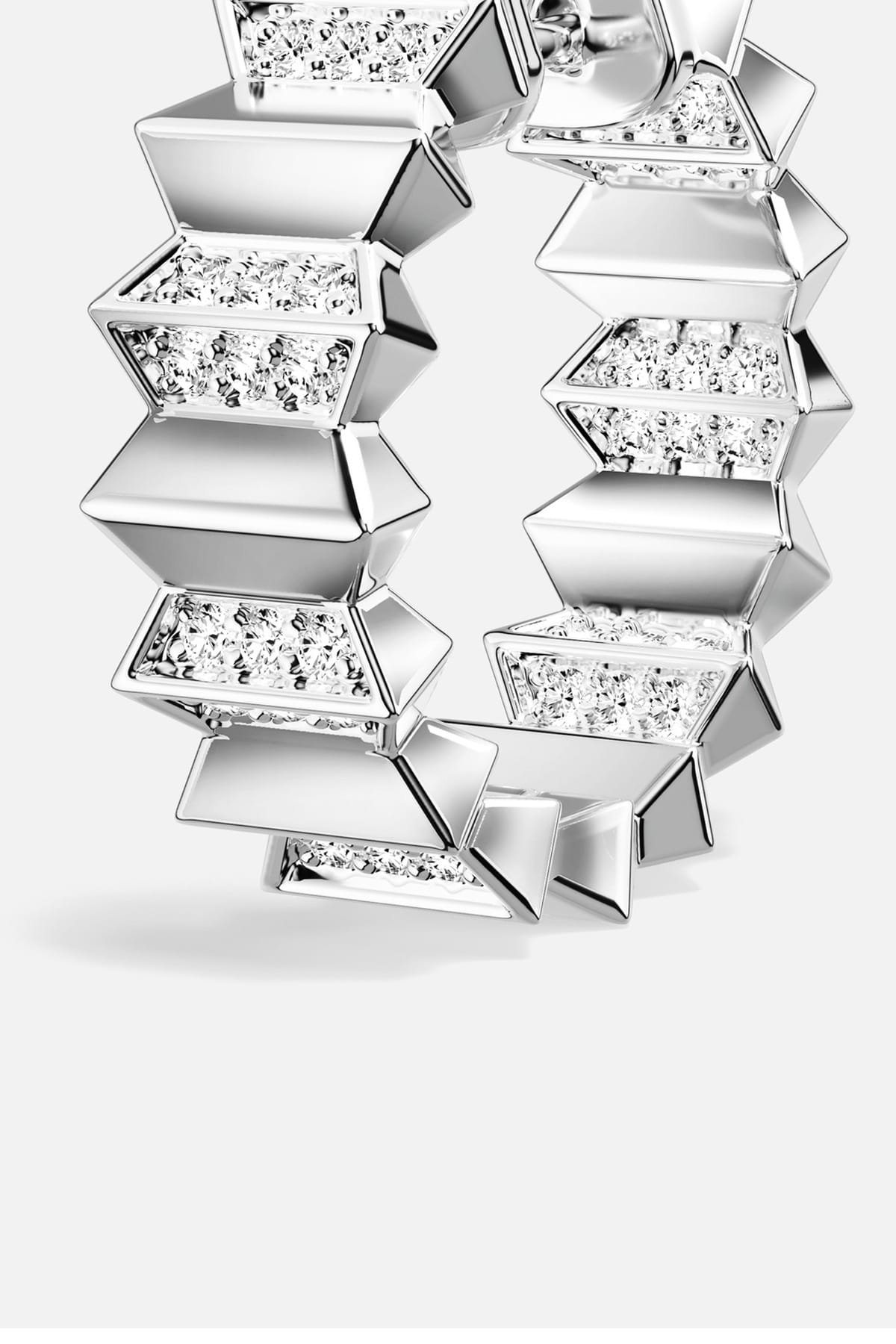 APM Hoop Earrings, sculpted geometry and rhodium finish shimmer with modern edge.