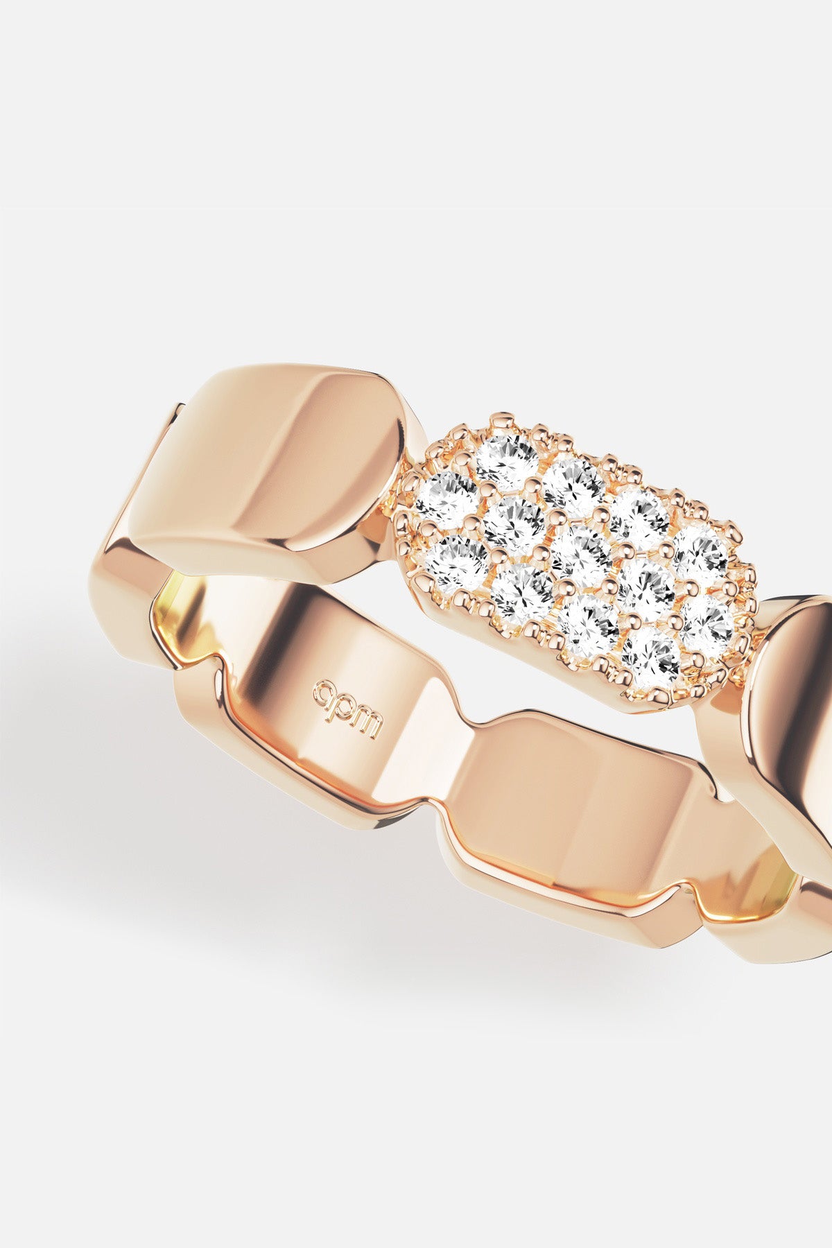 APM Ring in warm rose color, sculpted links meeting a delicate shimmer of stones.