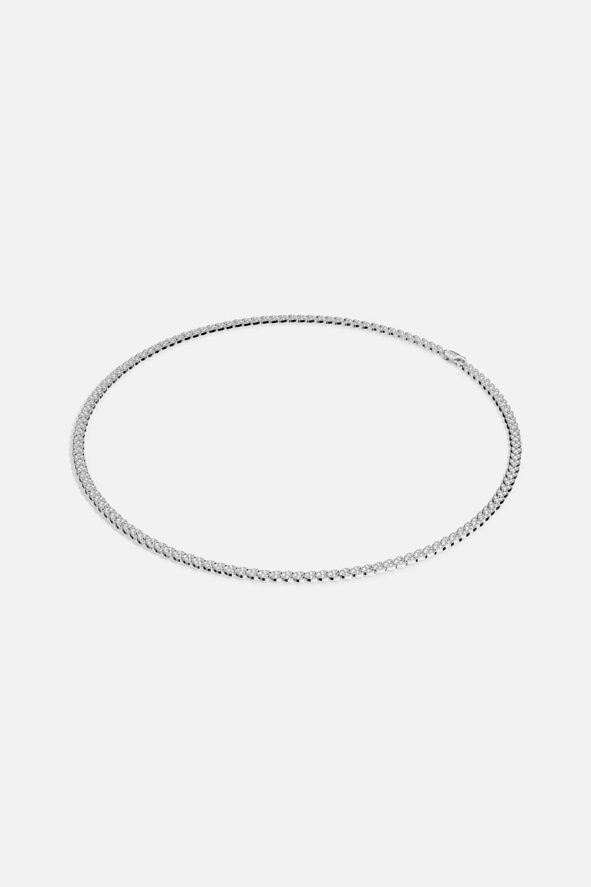 APM Tennis Necklace, a timeless line of light encircling every look with quiet brilliance.