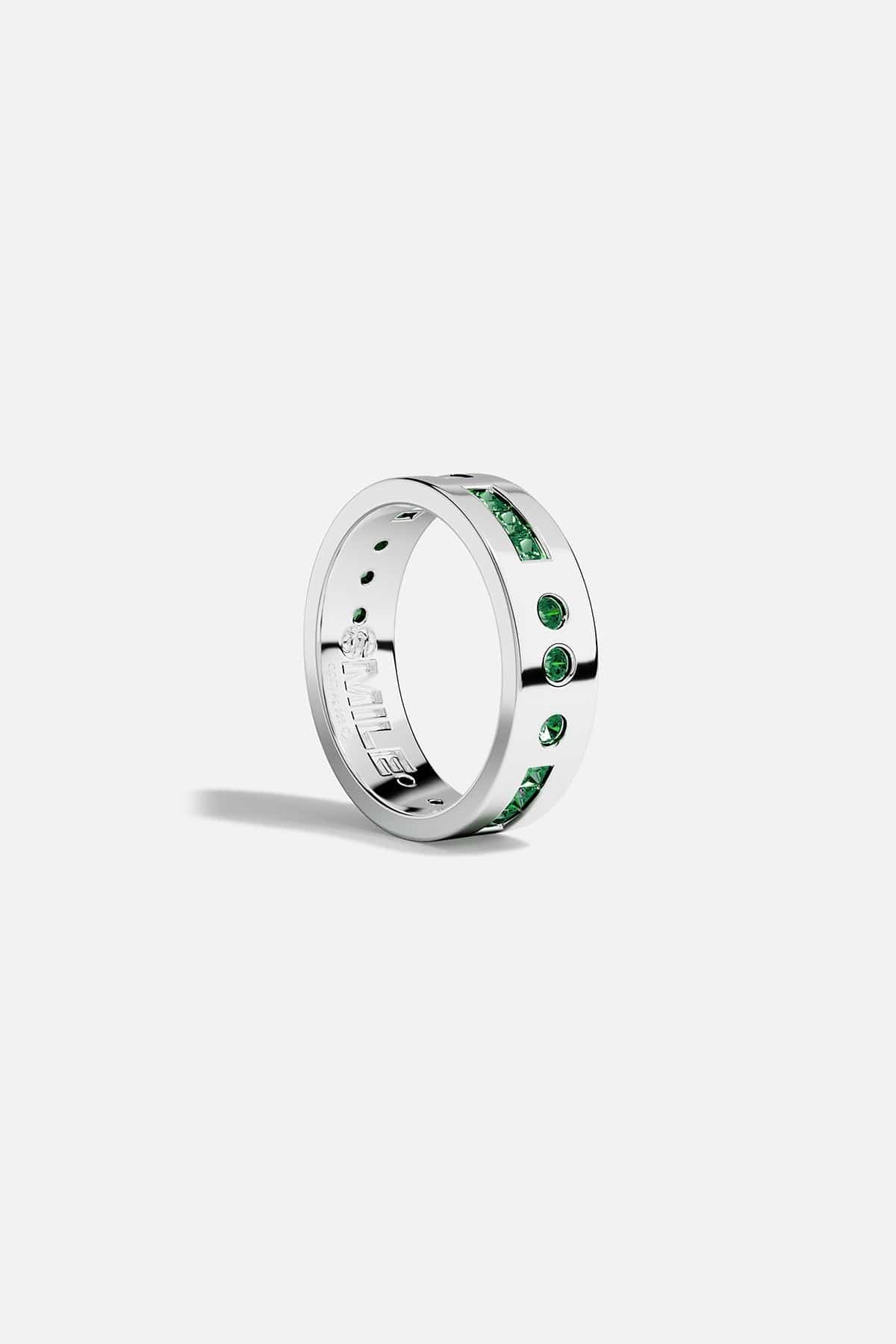 Silver ring with green stones on a white background
