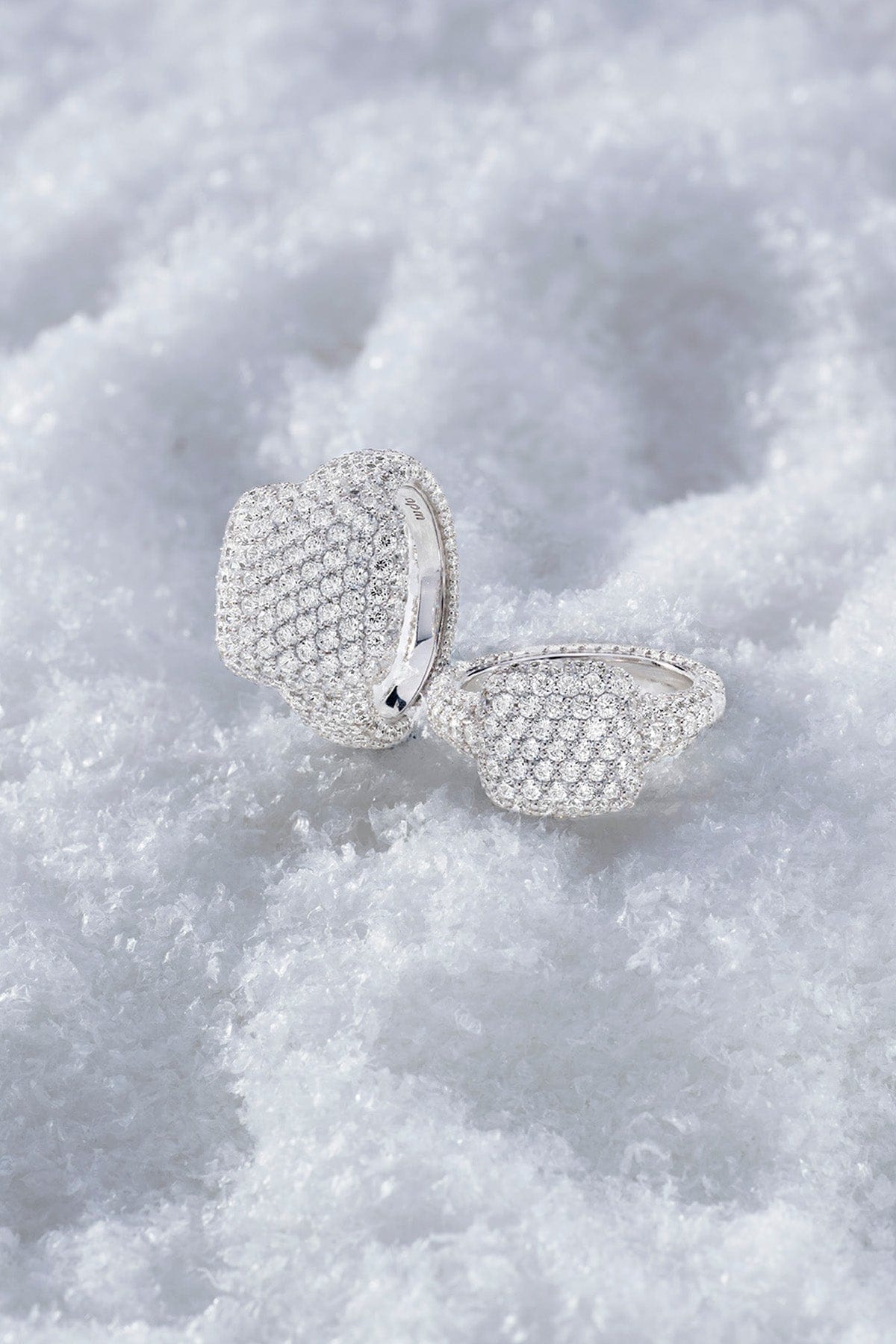 APM MONACO statement pave ring in silver on a textured white snow surface