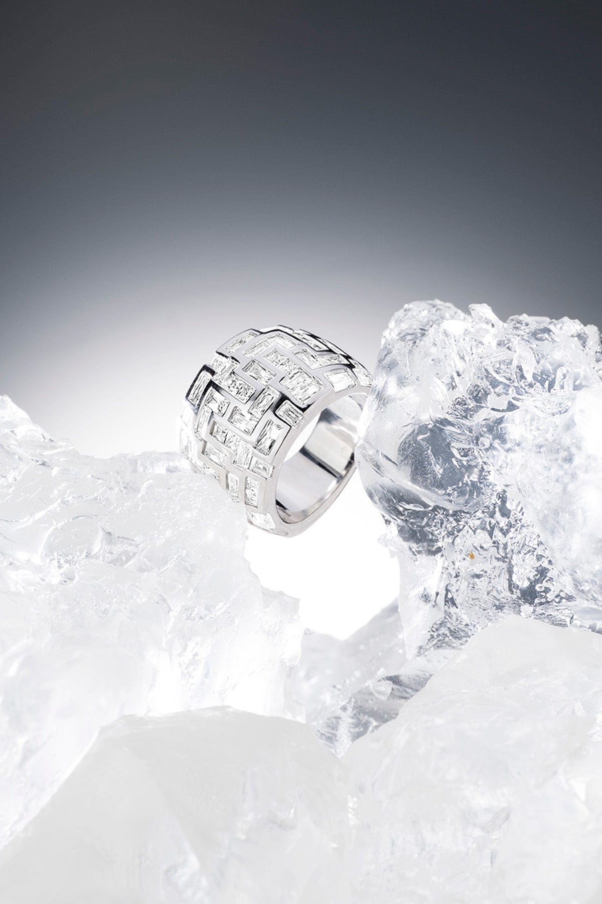 APM MONACO chunky labyrinth ring in silver on a textured iced surface