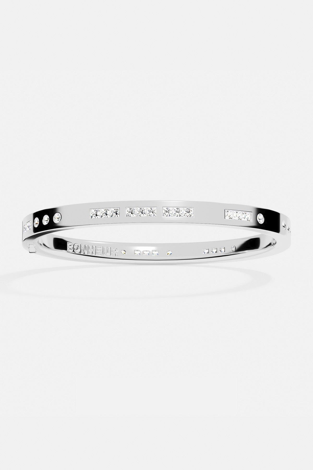 Bracelets APM Monaco, white-silver morse-code bangle with pavé stones along a delicate line.