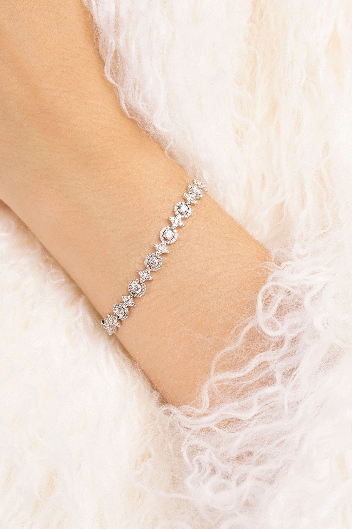 Silver bracelet on a wrist with a soft white background