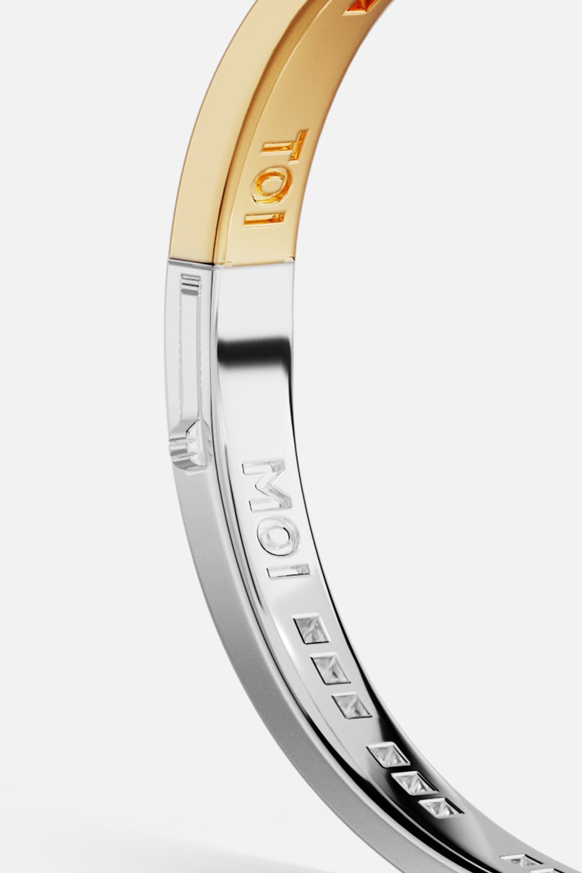 Bracelets APM Monaco two-tone Toi Moi bangle, white and yellow gold tones, engraved with the brand name and geometric shapes.