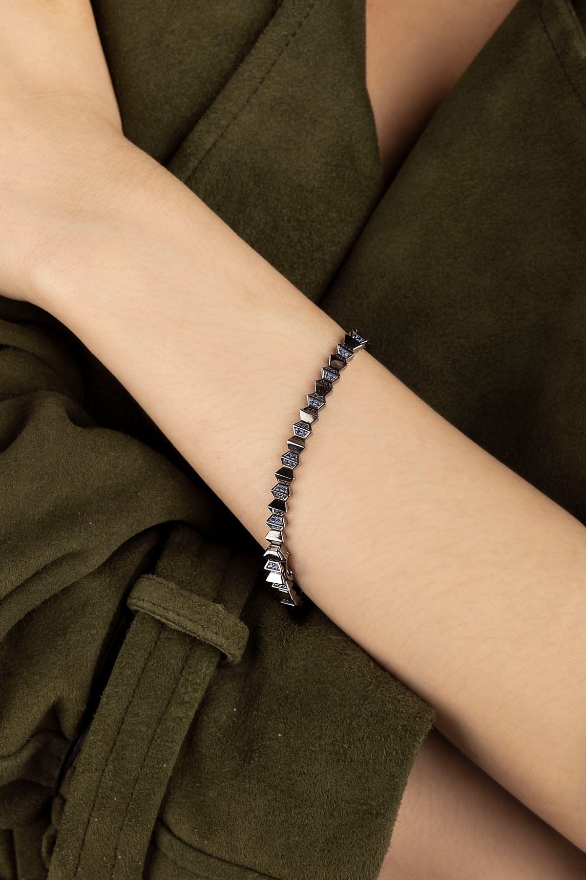 APM Monaco Up and Down Bracelet in dark grey on a wrist against a green background