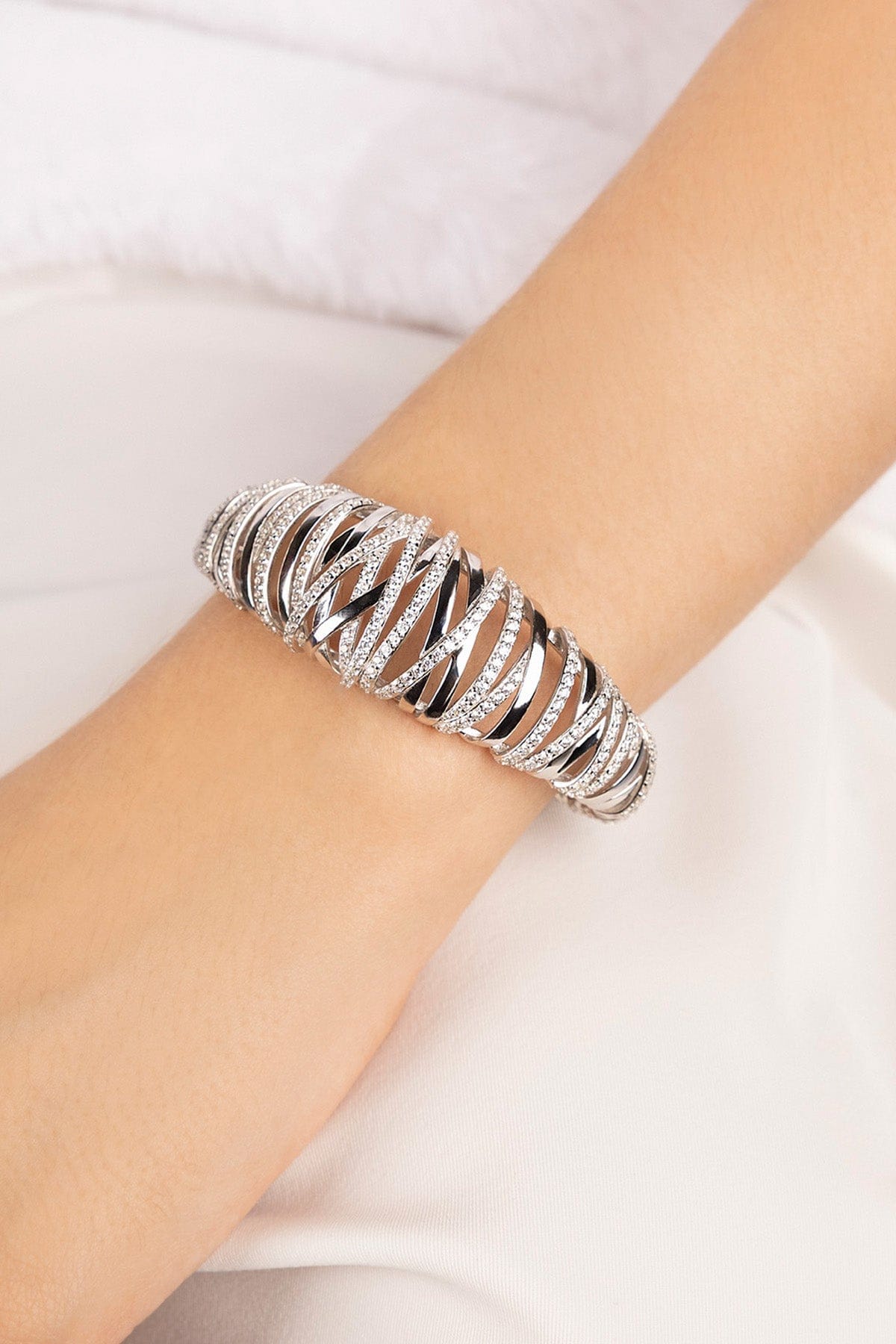 APM MONACO enlace bracelet in silver on a wrist with a white background