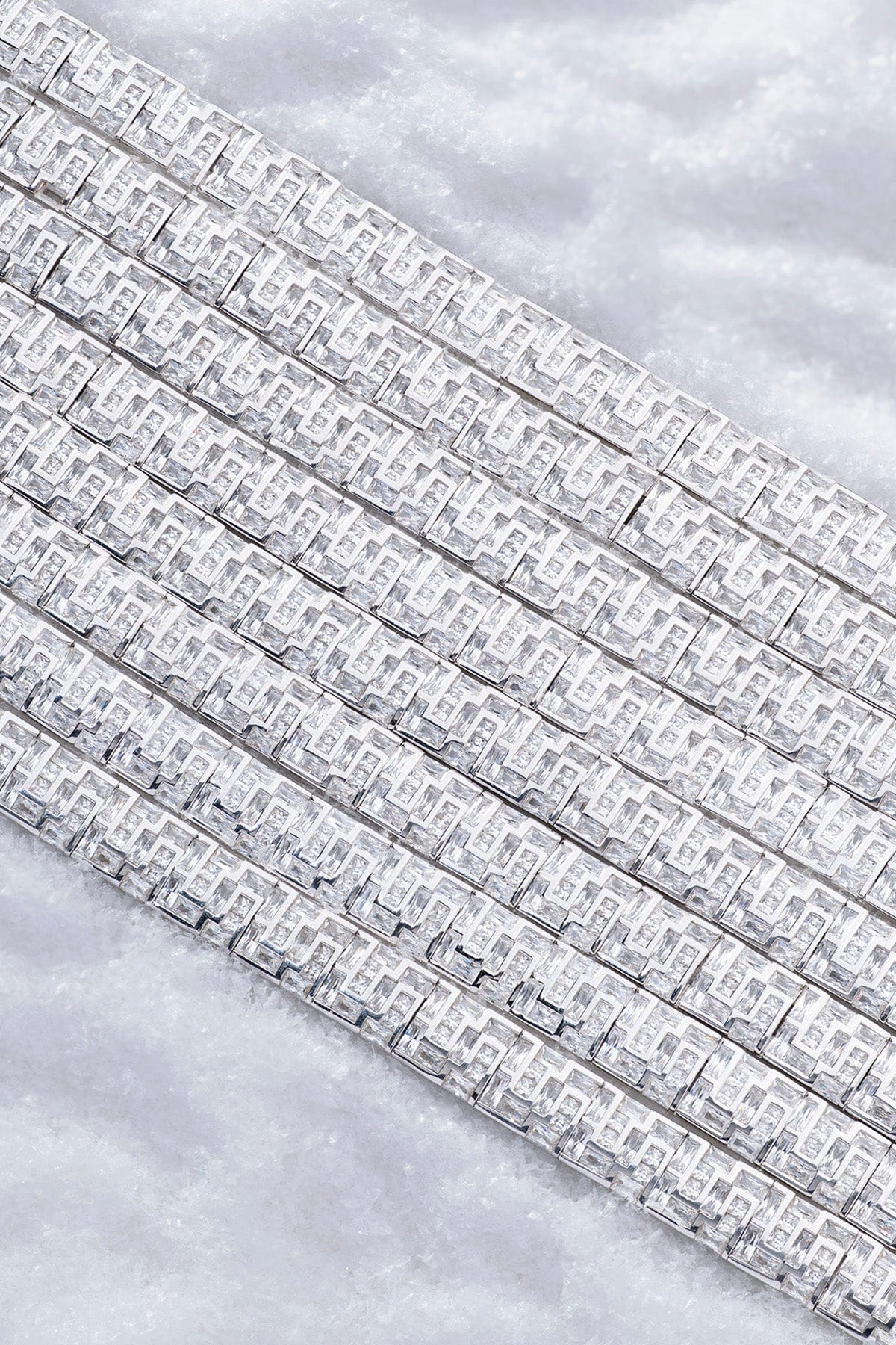 APM MONACO chunky labyrinth silver bracelet on a light iced surface