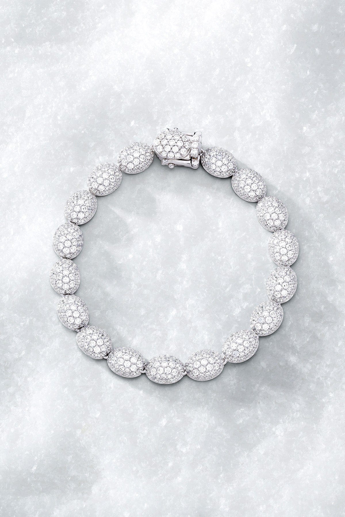APM MONACO pave bracelet in silver with a textured design on a light grey surface