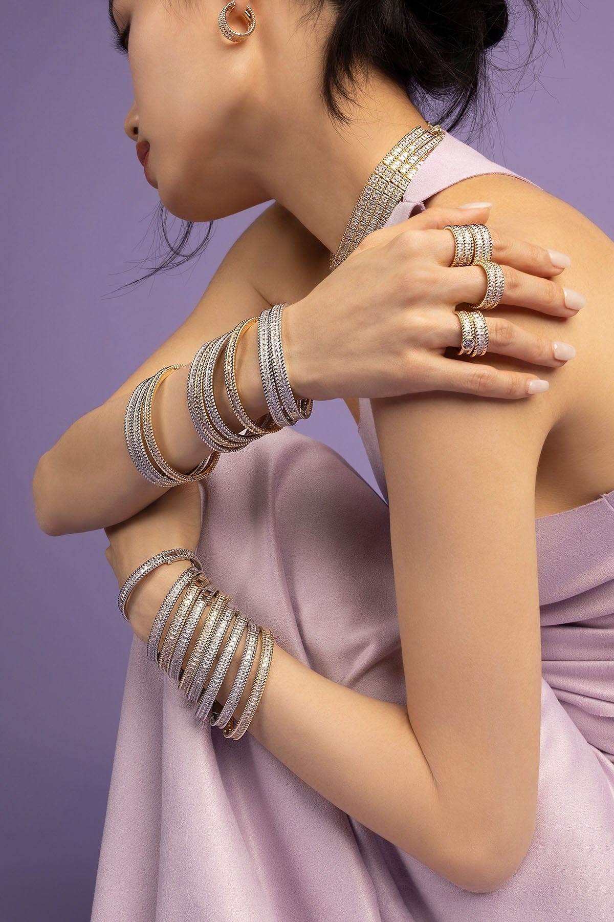 Silver bracelet on a person's wrist against a purple background