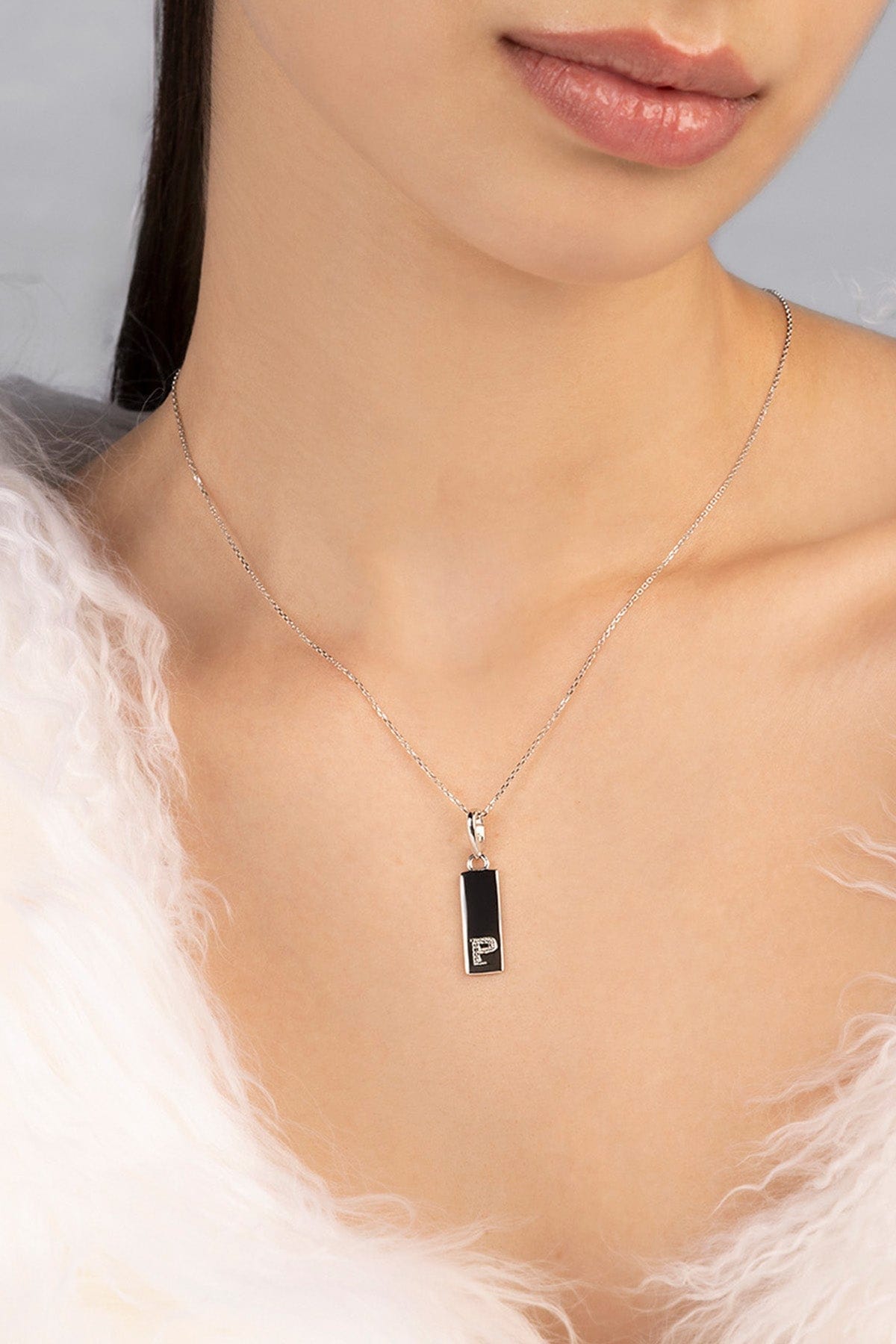 Necklace with a pendant featuring the letter "P" in white zirconia stones.