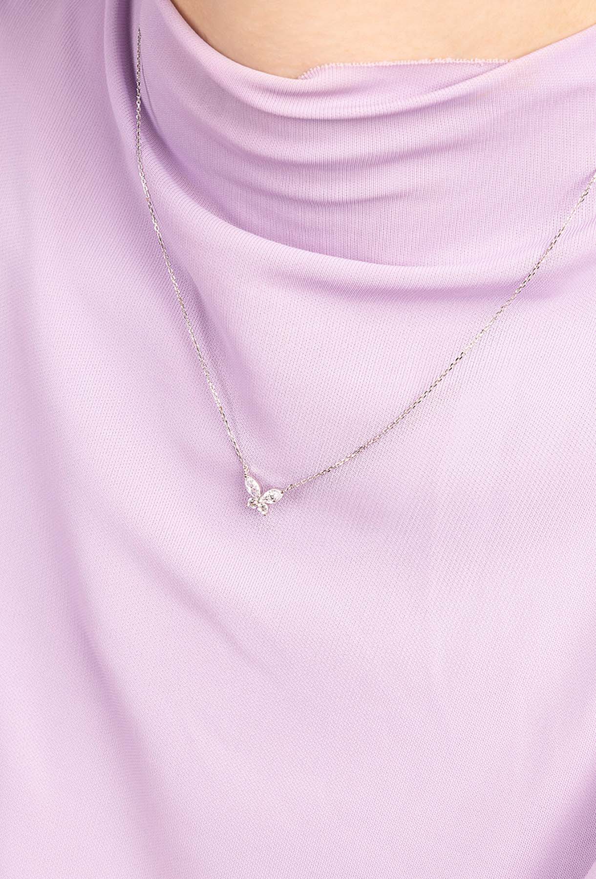 Necklace with a small pendant on a light purple top