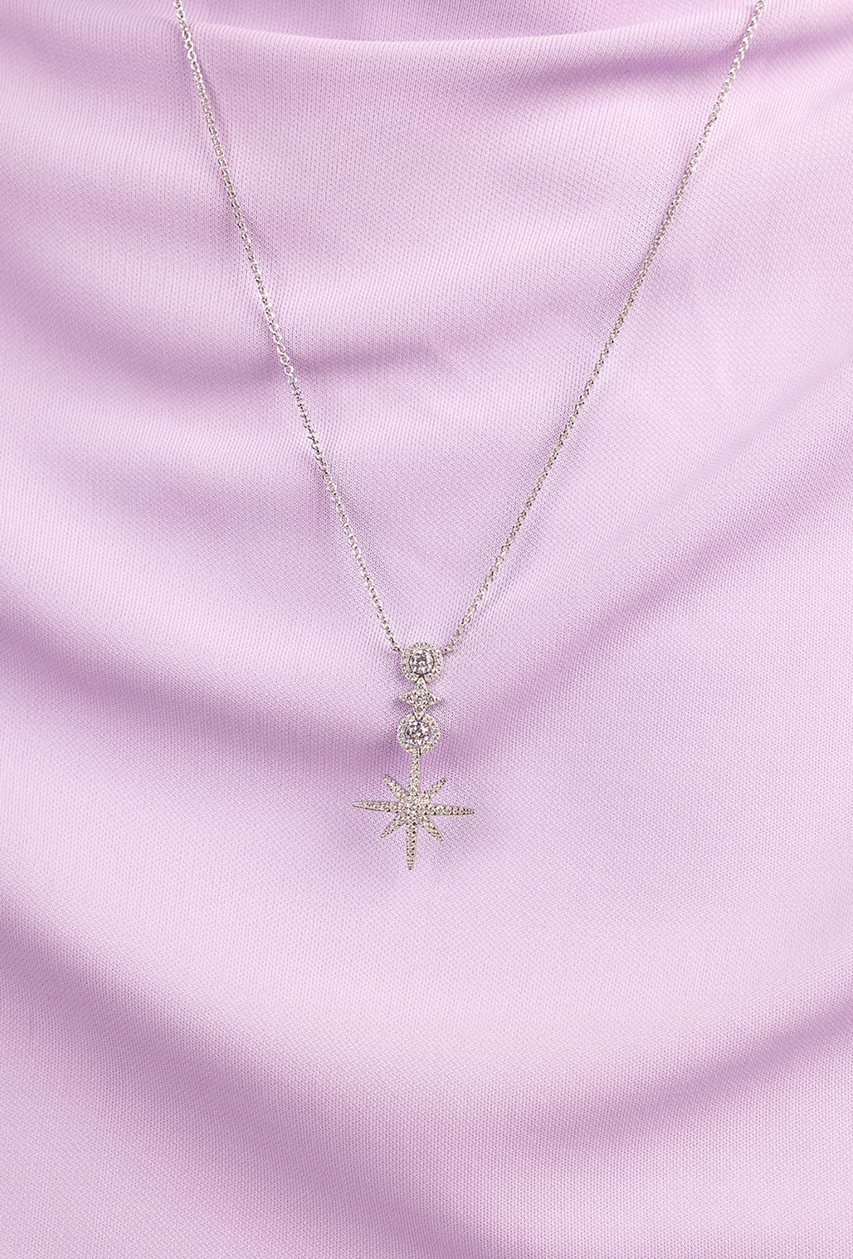 APM MONACO white necklace with a star-shaped pendant worn by a person