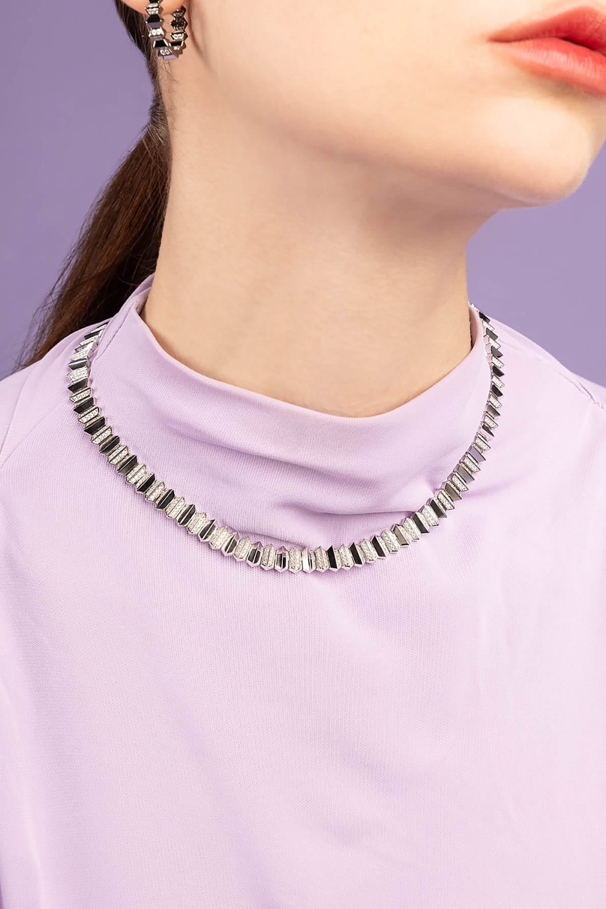 APM MONACO UP AND DOWN Necklace worn by a person with a purple background