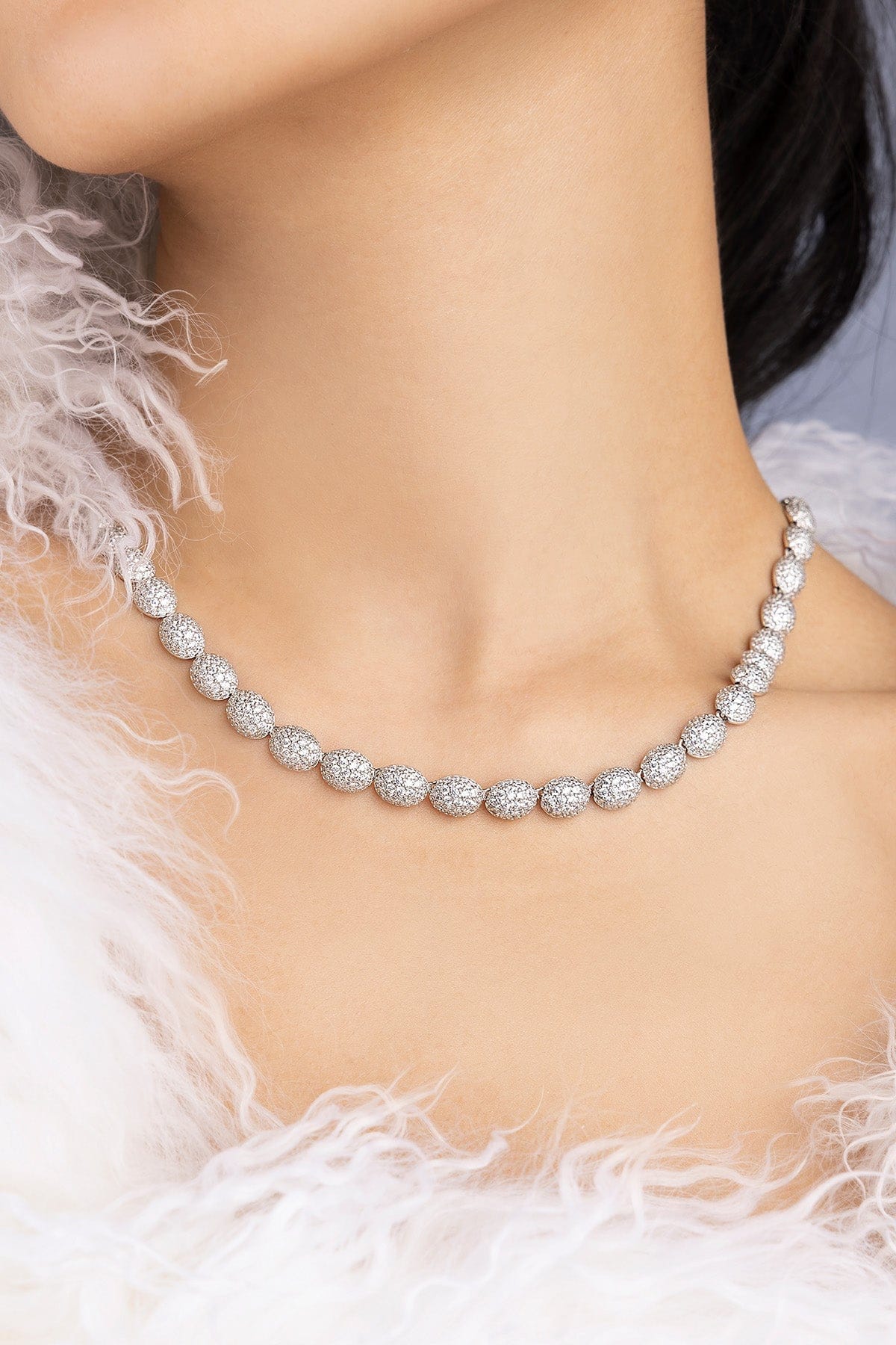 Necklace on neck with a white feathered garment