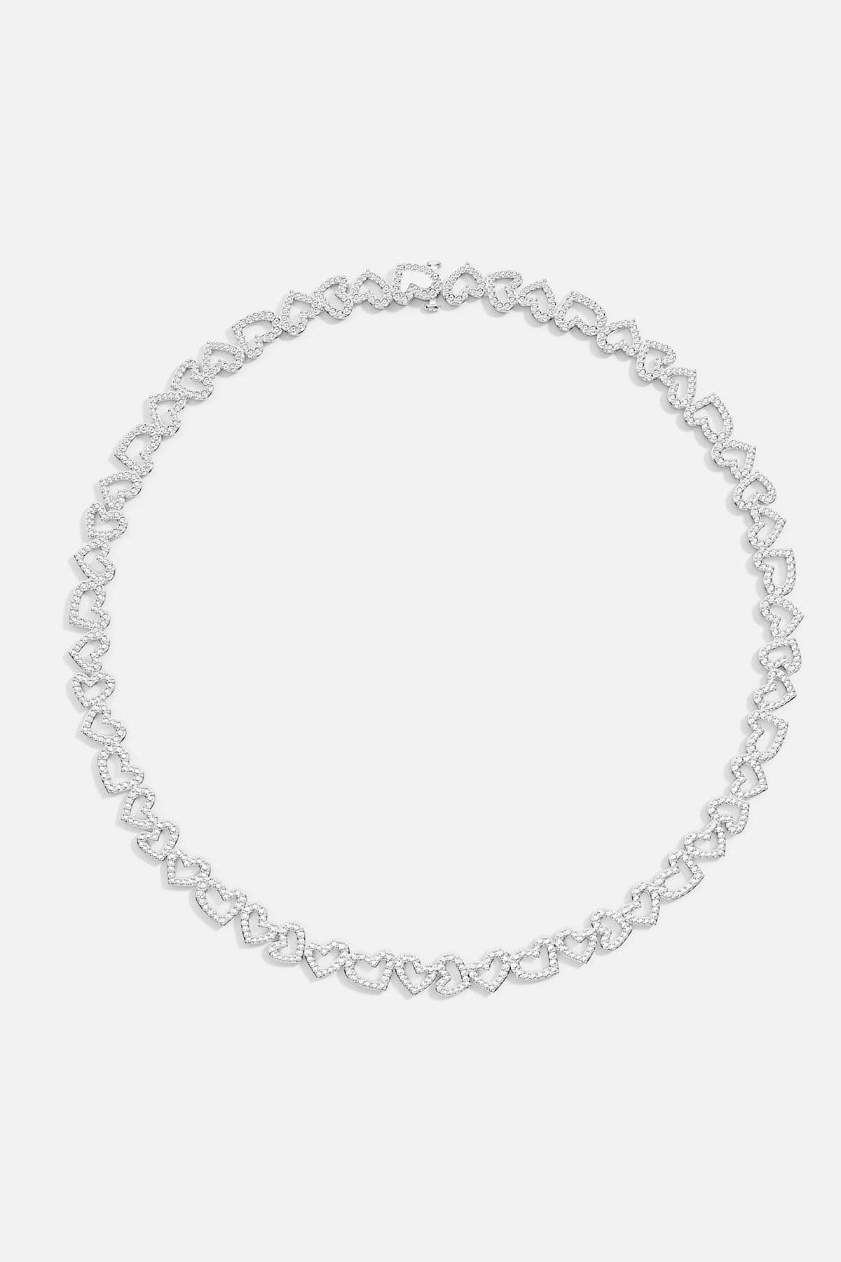 APM MONACO silver heart-shaped necklace on a light gray background