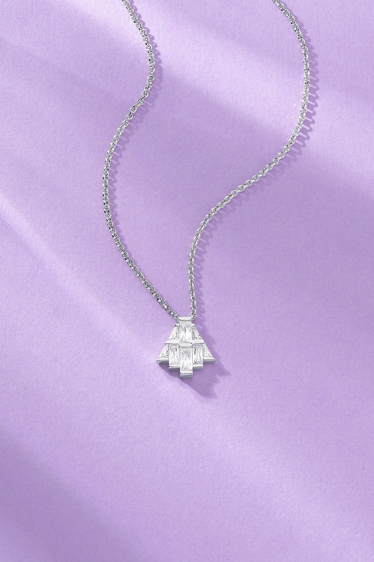 art deco necklace paved with white zirconia on a purple background