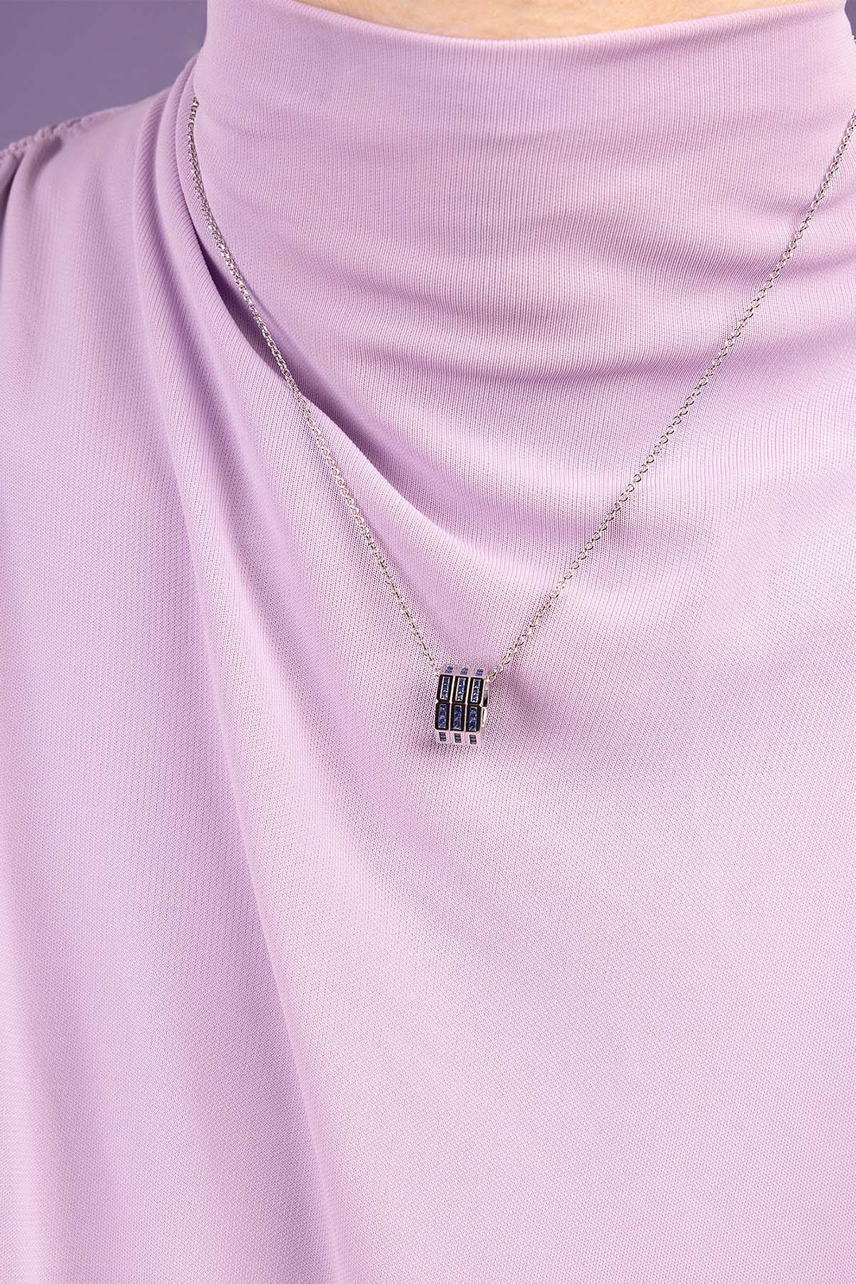 Necklace with a pendant on a person wearing a light purple top