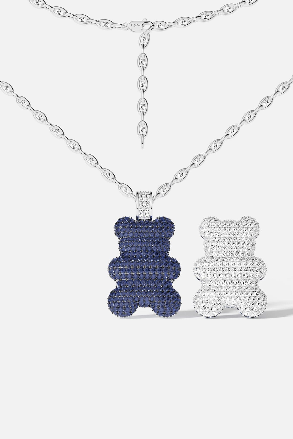 A bear-shaped pendant with different color on both side: blue and silver, on a white background.