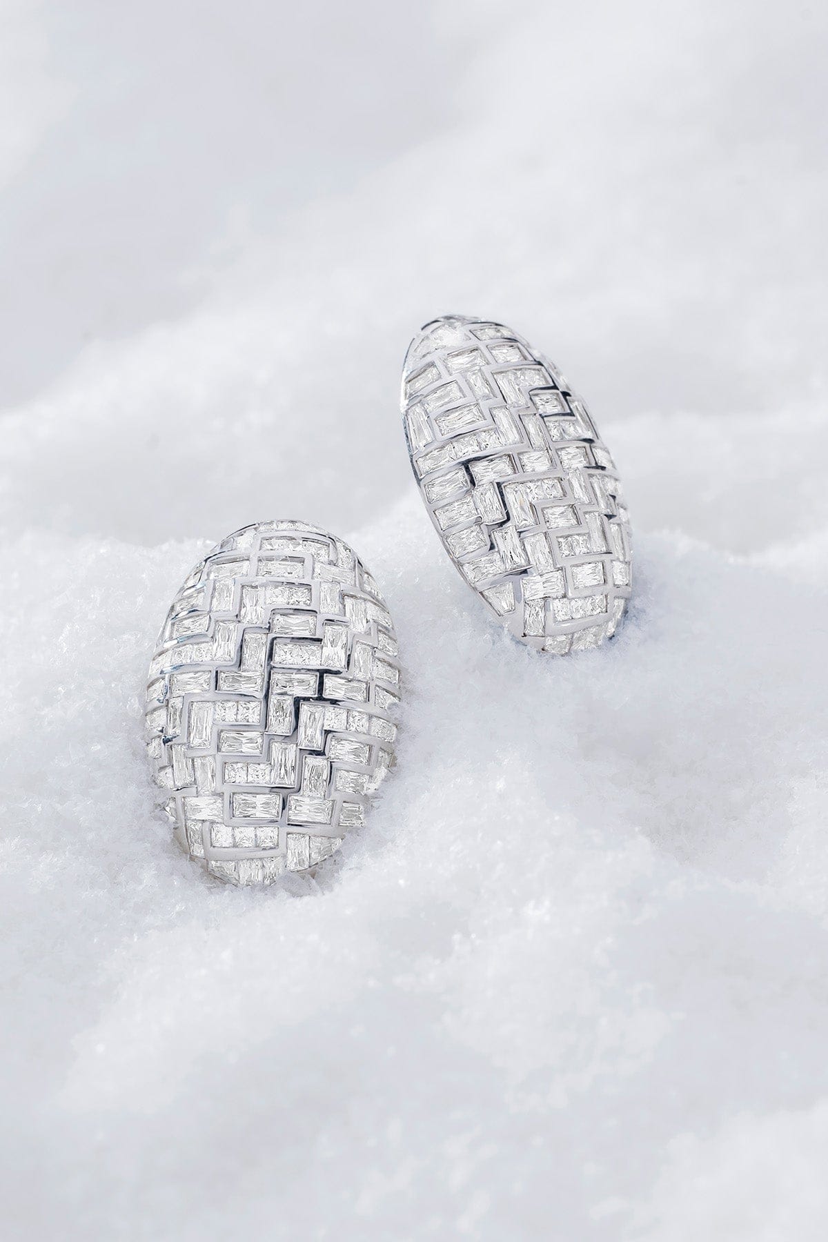 Pair of statement labyrinth earrings in silver from APM MONACO and on a soft white surface